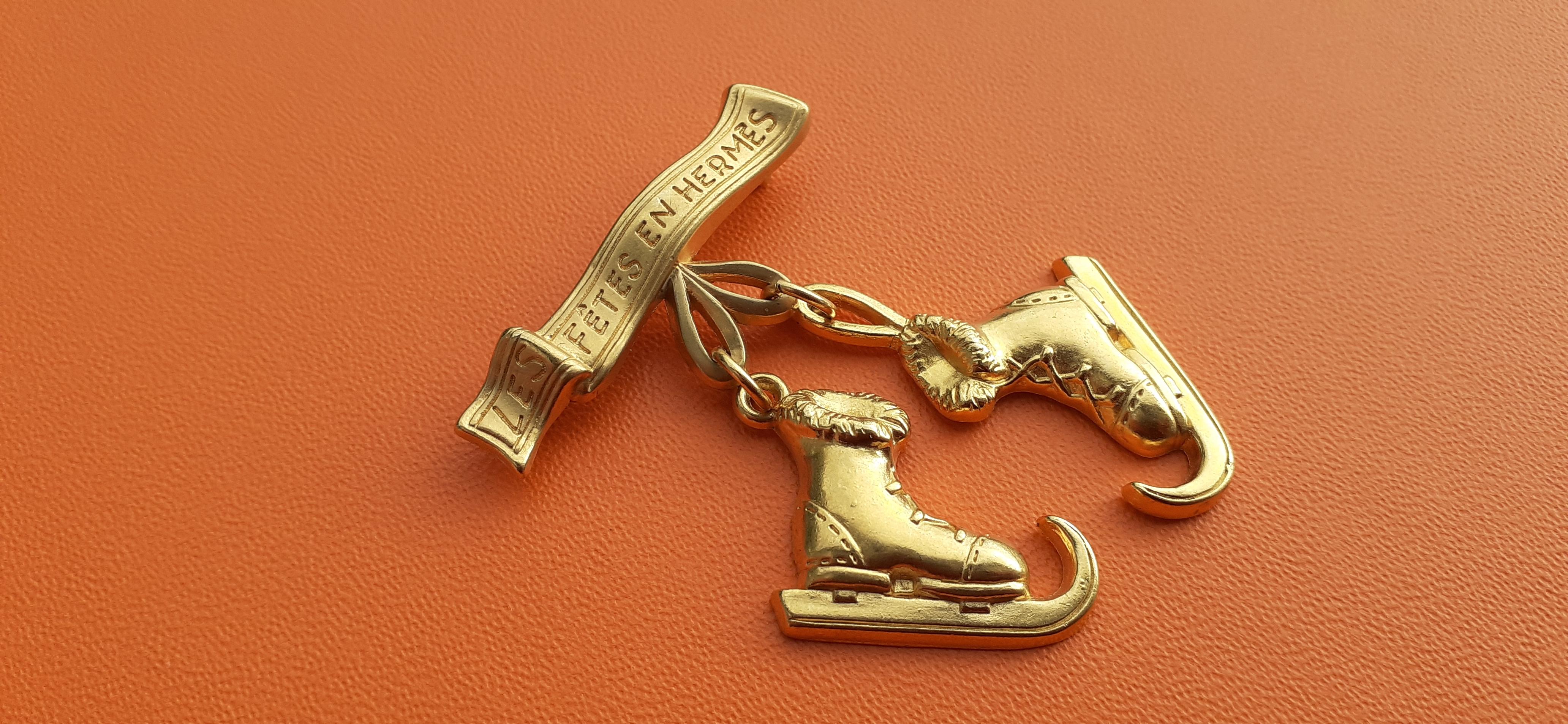 Beautiful Authentic Hermès Brooch

2 mobile charms in shape of ice skates

In the banner is written 
