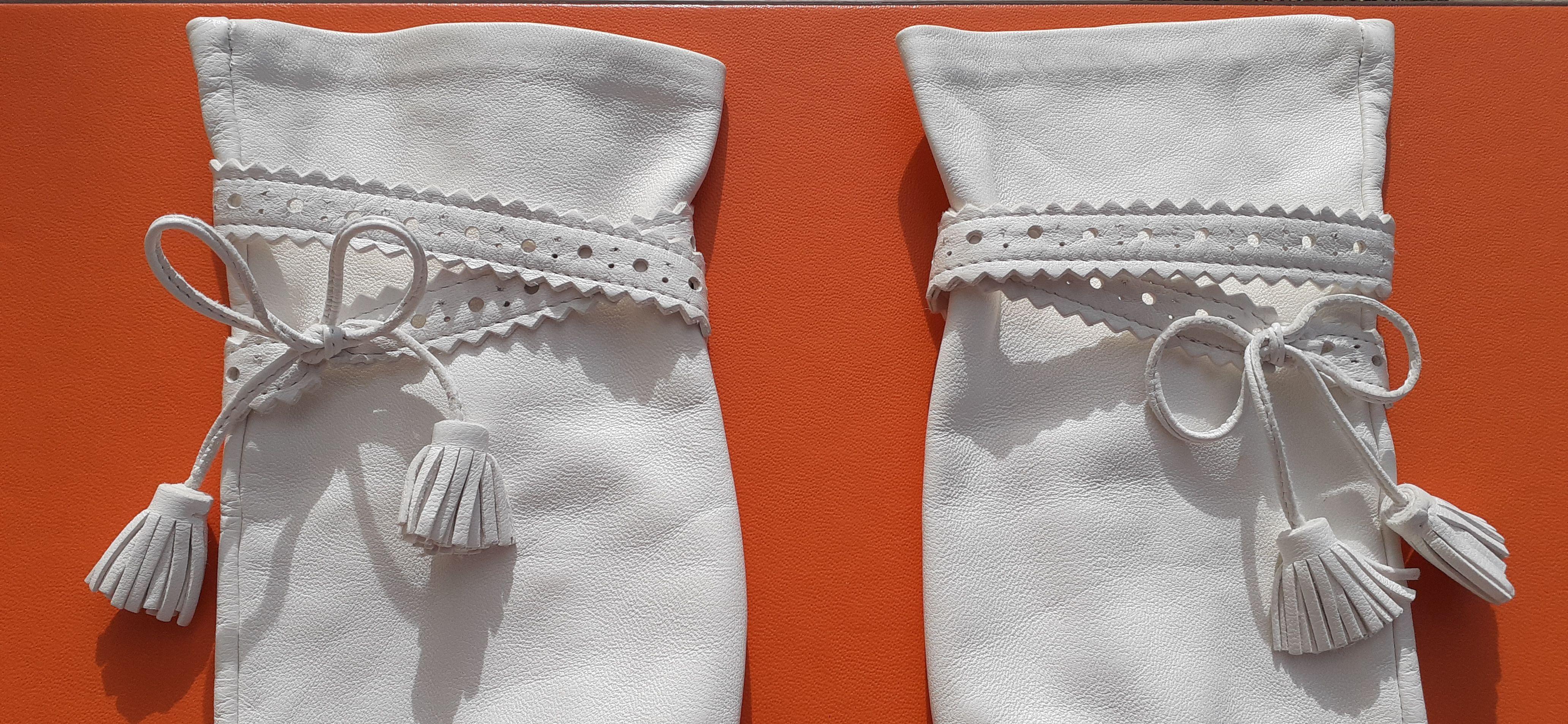 Wunderschöne authentische Hermès Handschuhe 

Hergestellt in Frankreich

Hergestellt aus glattem Lammleder 

Mit Seide gefüttert

Verziert mit GHILLI-Schleifen, die mit silbernen Druckknöpfen mit Gravur 