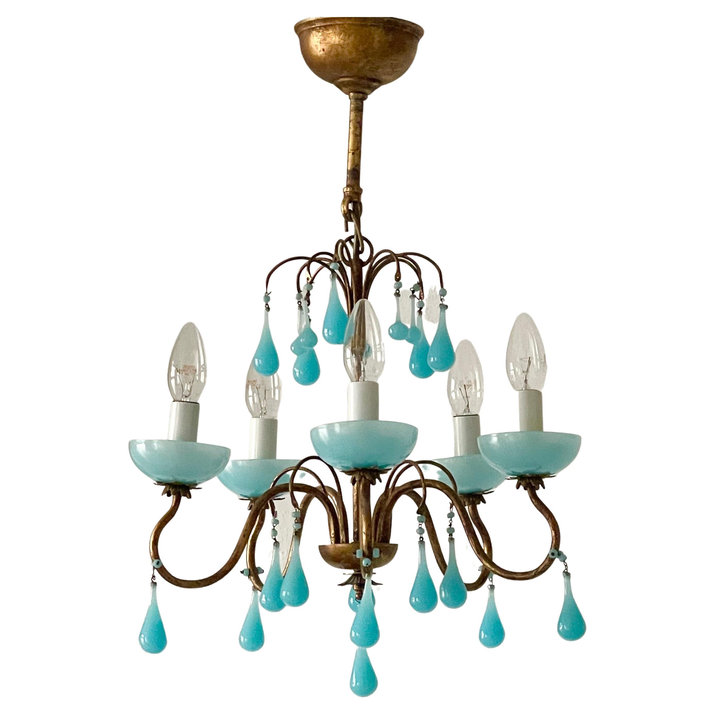 A wonderful aqua opaline blue chandelier, Italy, circa 1930s.
This beautiful handcrafted chandelier is made of patinated metal/iron decorated with aqua opaline blue Murano glass drops.
Socket: e 14 for standard screw bulbs.
Dimensions: H23.22