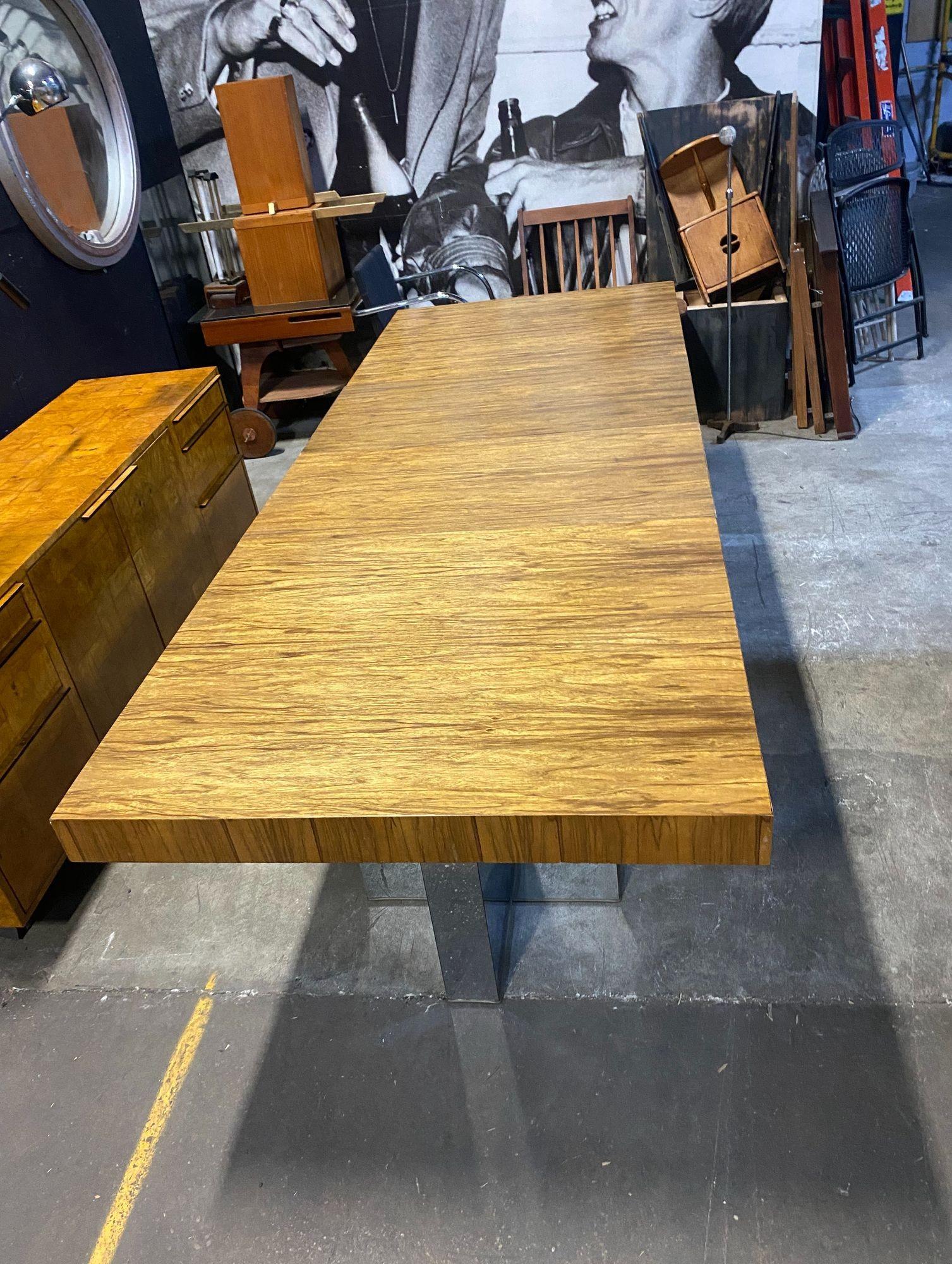 Aquí tienes una preciosa mesa de comedor Milo Baughman vintage de madera de encaje. Se asienta sobre dos bases cruciformes de acero pulido y tiene dos grandes hojas.  La mesa mide 40 de ancho por 66