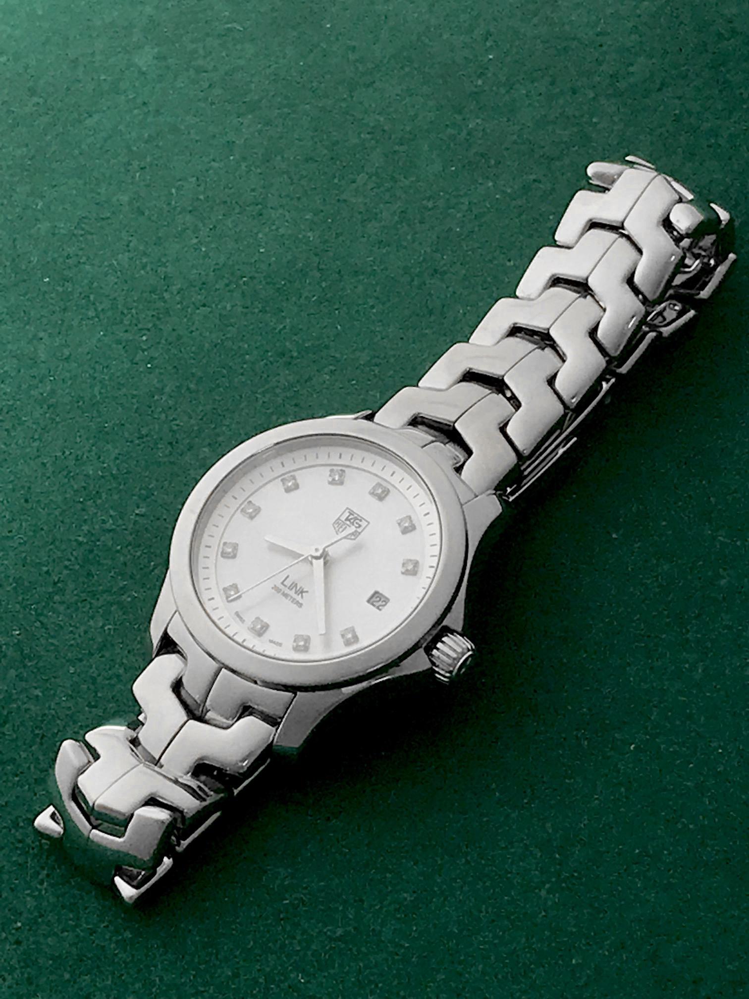 Stunning Preowned Ladies' Tag-Herum Link wristwatch with Stainless Steel case and Mother of Pearl Dial with Diamond Markers. Stainless Steel case (27mm dia.). Water-Resistant to 200 Meters - 660 Feet. Stainless Steel Tag-Heuer bracelet with