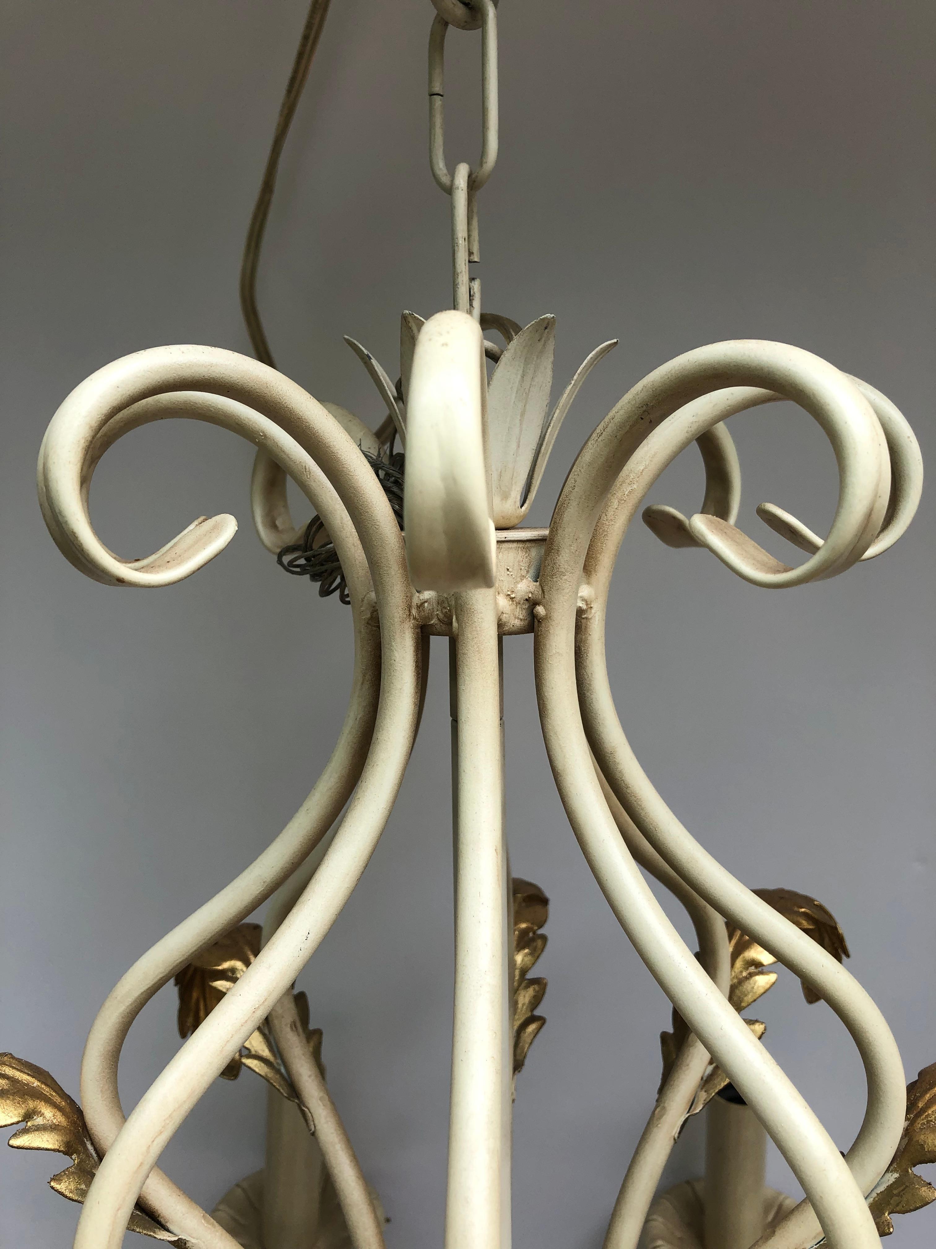 Beautiful off white painted metal 8 arm chandelier having pretty shape with curlicues and gold leaf acanthus leaf decoration.