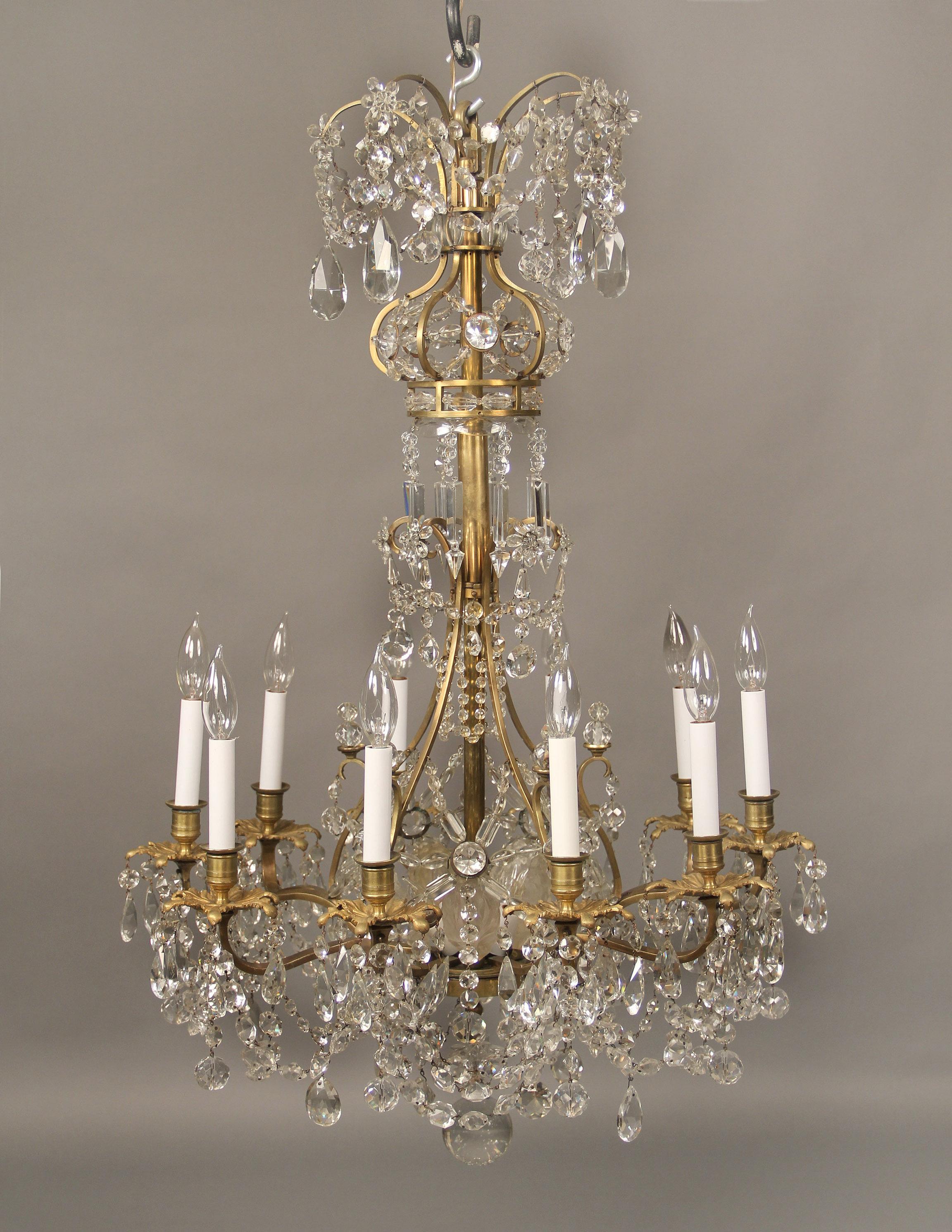A lovely late 19th century gilt bronze and baccarat crystal fifteen light chandelier

Multifaceted and shaped crystals with drop pendants, balls and beads, the top shaped as a crown, the center lights surrounded by frosted crystal leaves, ten