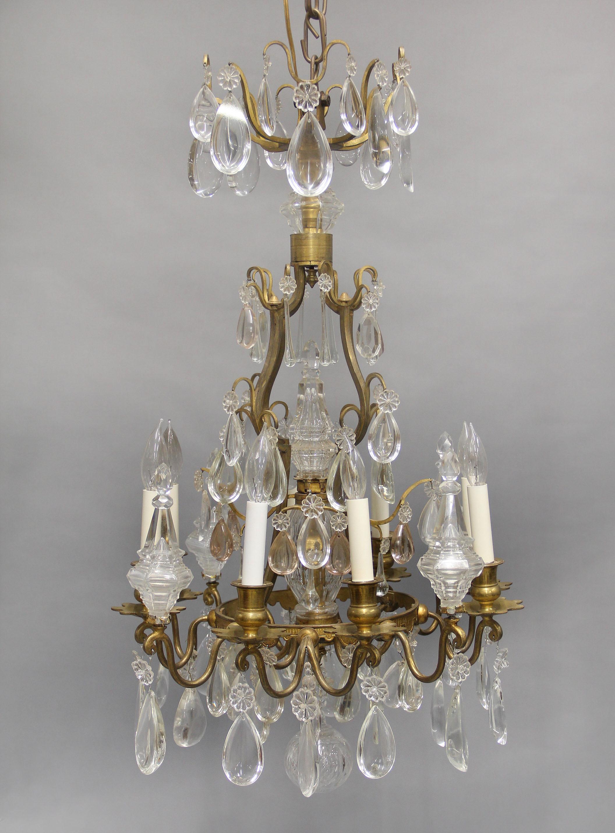 A Lovely Late 19th Century Gilt Bronze and Crystal Eight Light Chandelier

Multi-faceted and shaped tear drop crystals, cut crystal central column with a large central spear, with an additional four perimeter spears, eight total perimeter