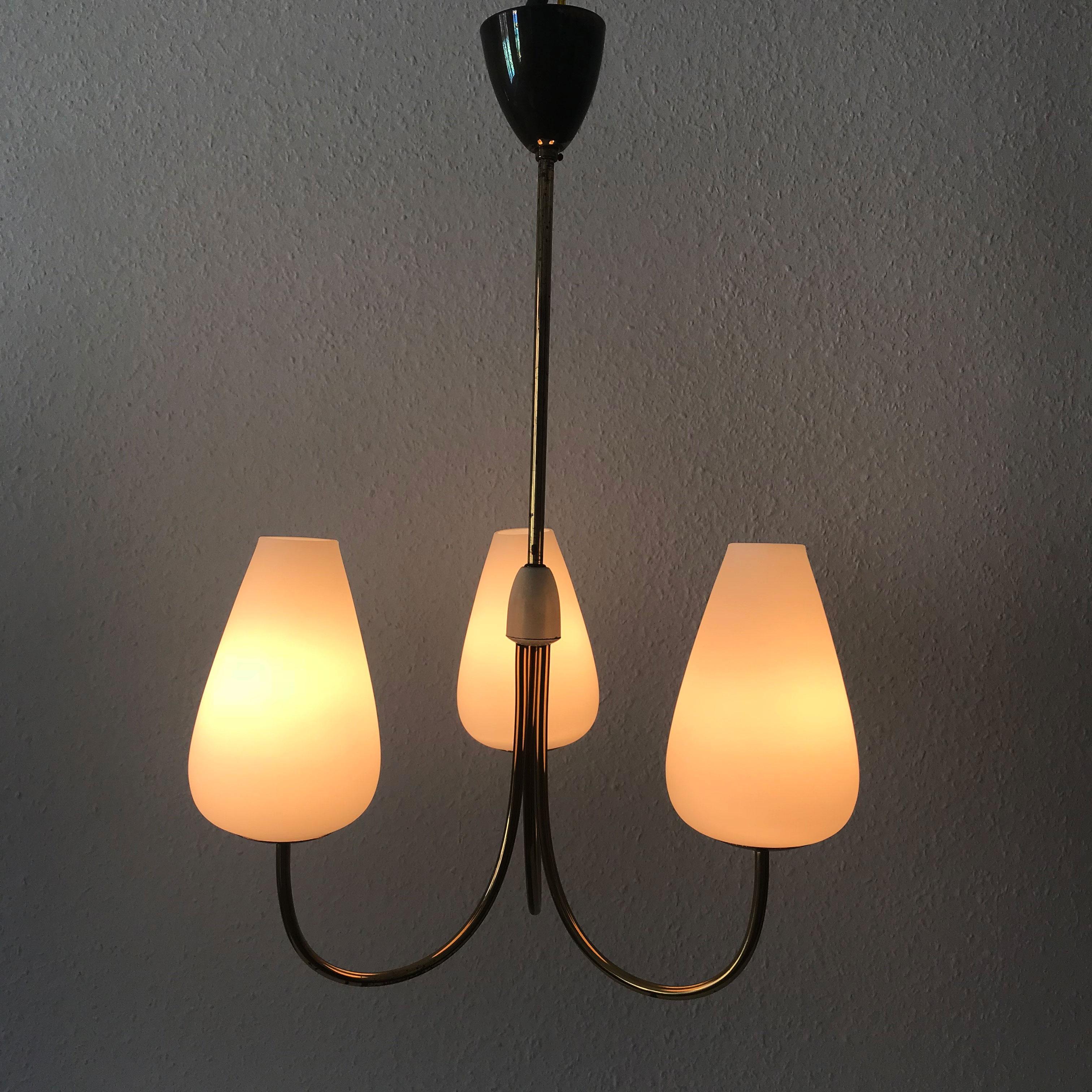 Elegant three-armed Mid-Century Modern chandelier or pendant lamp. Probably manufactured by Kaiser Leuchten, 1950s, Germany.

Executed in brass and opaline glass. The lamp needs three E14 Edison screw fit bulb, is re-wired and in working