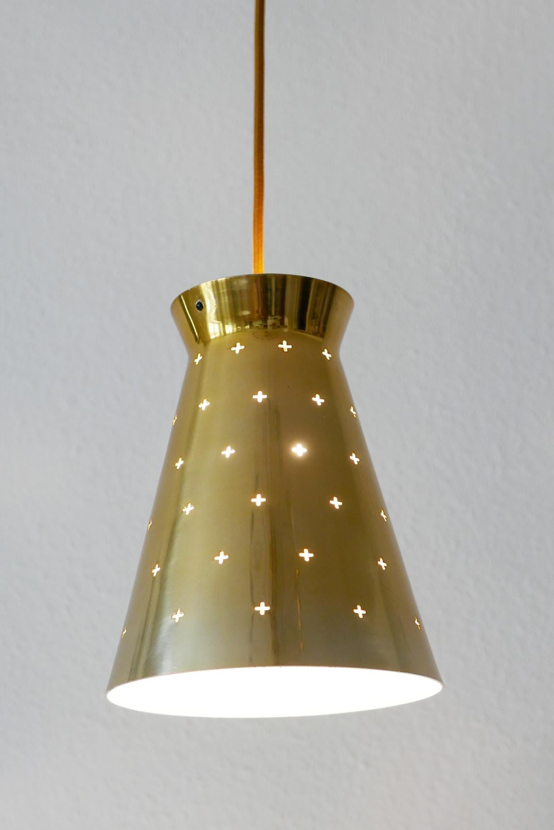Elegant Mid-Century Modern diabolo pendant lamp. Designed and manufactured by Hillebrand Leuchtenfabrik, 1950s, Germany.

Executed in perforated and brass anodized aluminium. The lamp needs 1 x E27 Edison screw fit bulb, is wired, and in working