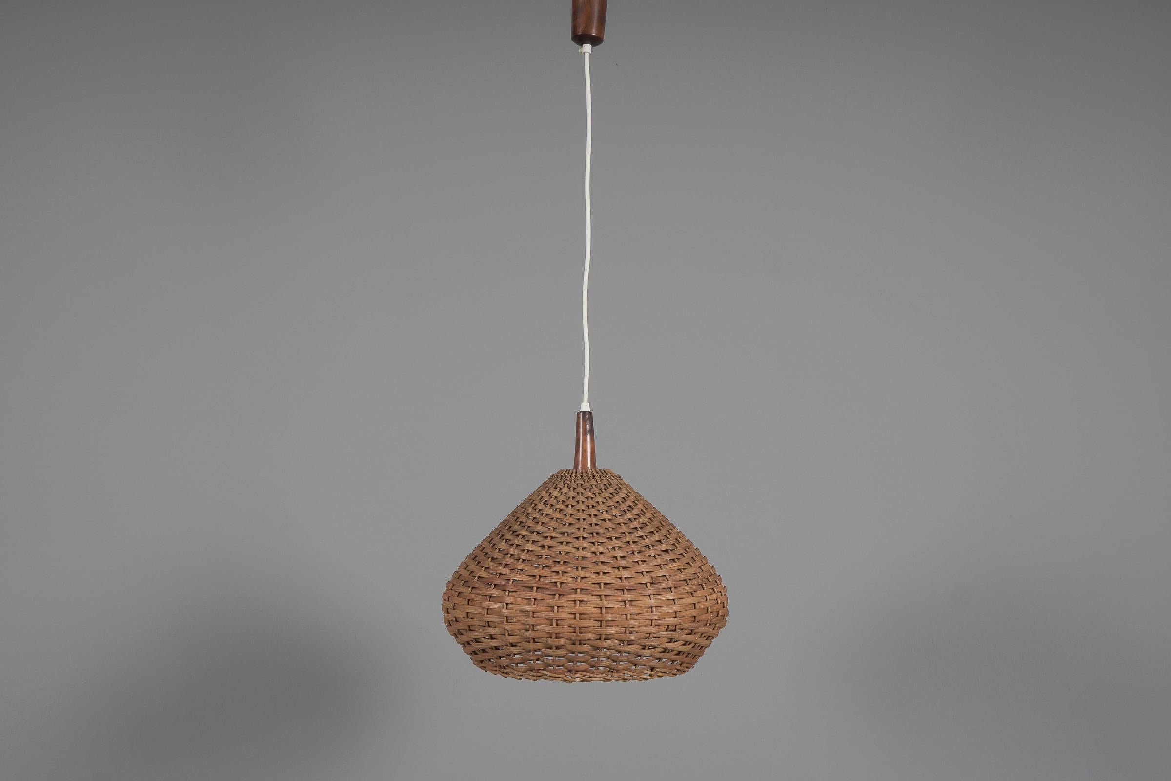 Rara e deliziosa lampada a sospensione decorativa del Mid-Century Modern. Progettato e prodotto probabilmente in Scandinavia, negli anni '1960.

La lampada può essere regolata fino a 50 cm di altezza.

Realizzata in rattan e legno, la lampada a