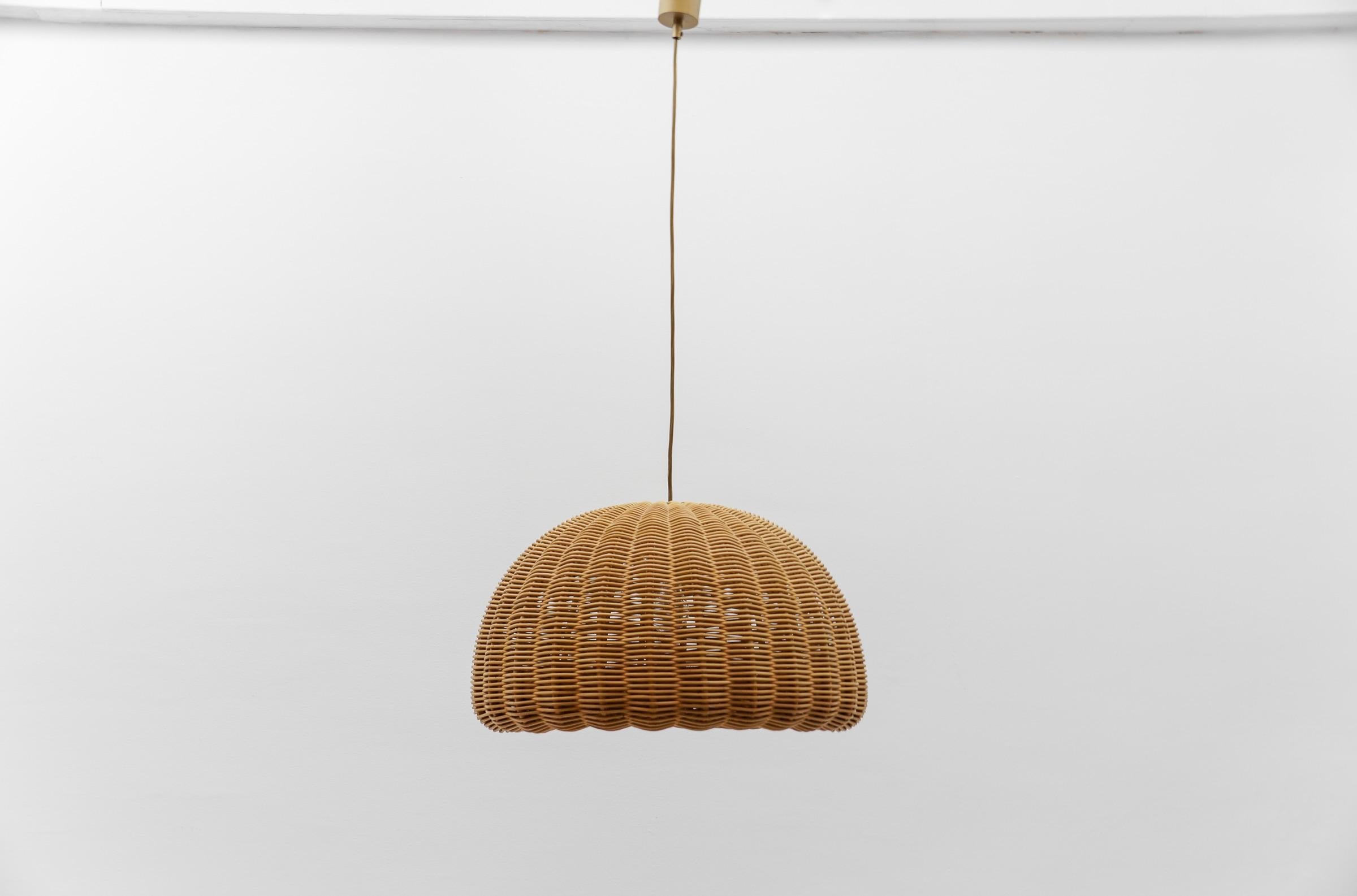 Rare and lovely decorative Mid-Century Modern pendant lamp. Designed and manufactured probably in Italy, 1960s.

The lamp can be adjusted up to 50cm height.

Executed in rattan and wood, the pendant lamp comes with 1 x E27 / E26 Edison screw fit