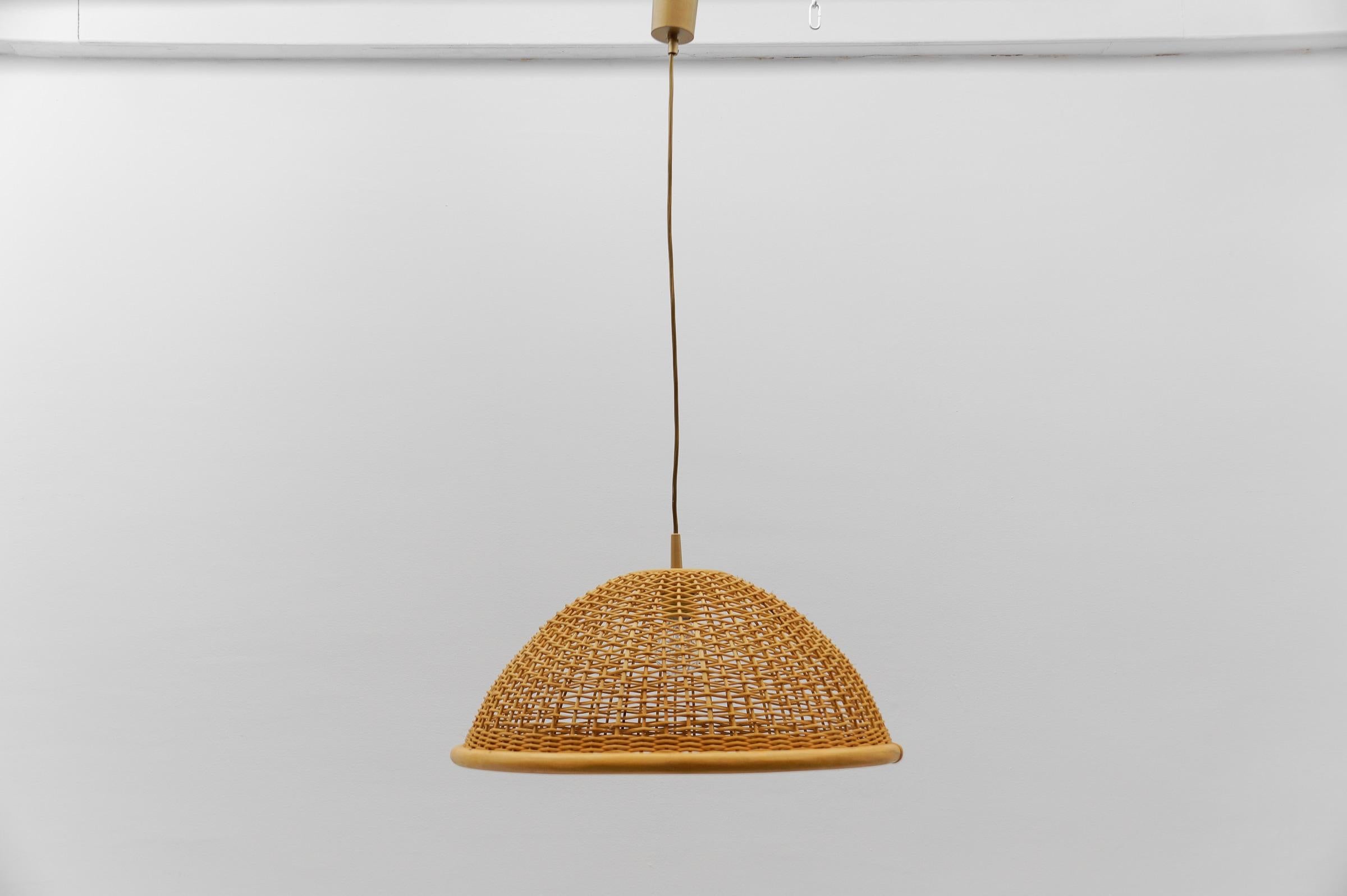 Rare and lovely decorative Mid-Century Modern pendant lamp. Designed and manufactured probably in Italy, 1960s.

The lamp can be adjusted up to 50cm height.

Executed in rattan and wood, the pendant lamp comes with 1 x E27 / E26 Edison screw fit