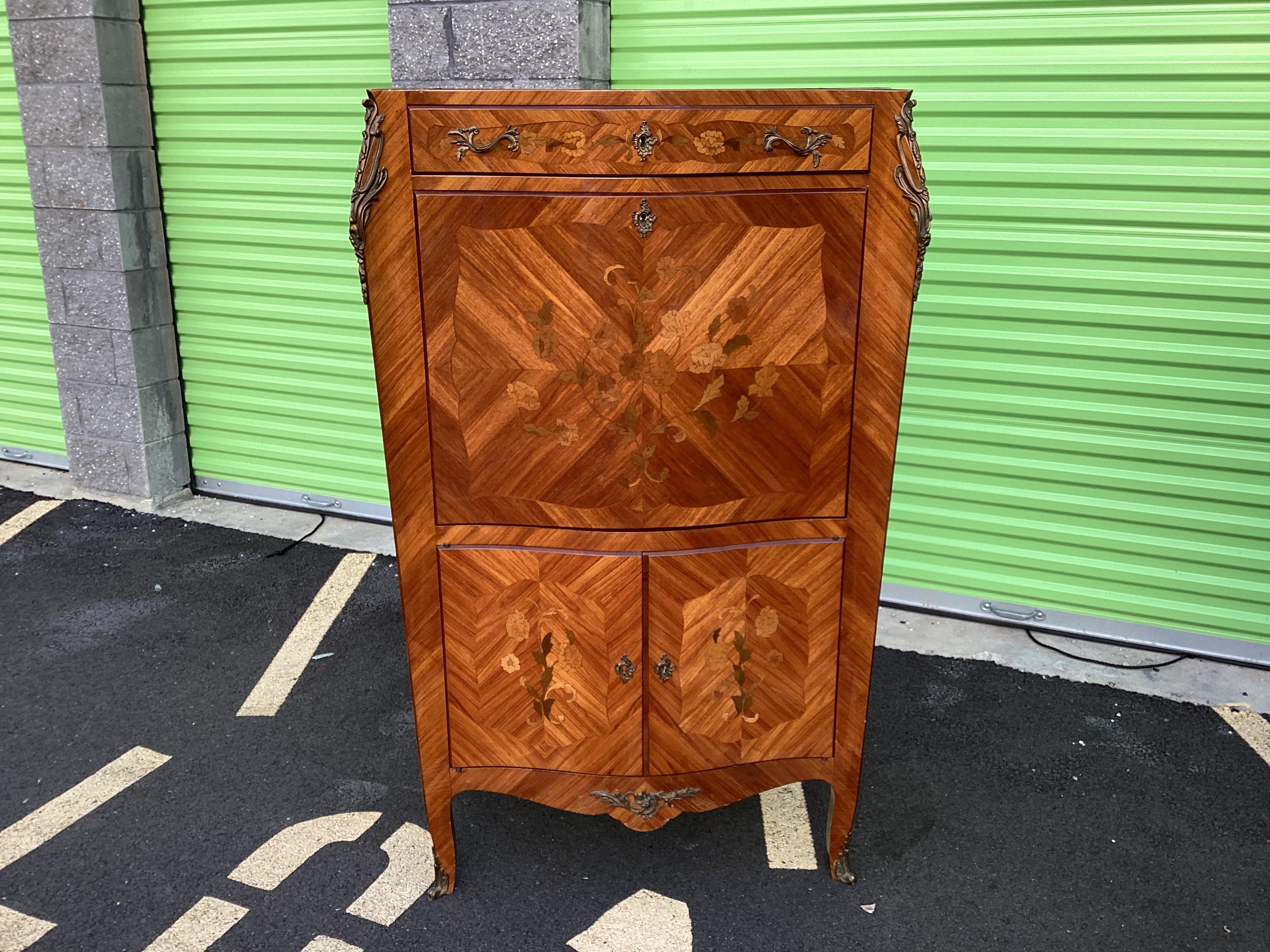 
Exceptional classic French secretary having stunning floral inlay on all sides with a variety of different color woods.  The interior features 6 drawers, an open shelf, and additional spaces for letters. A gorgeous pink leather work space completes