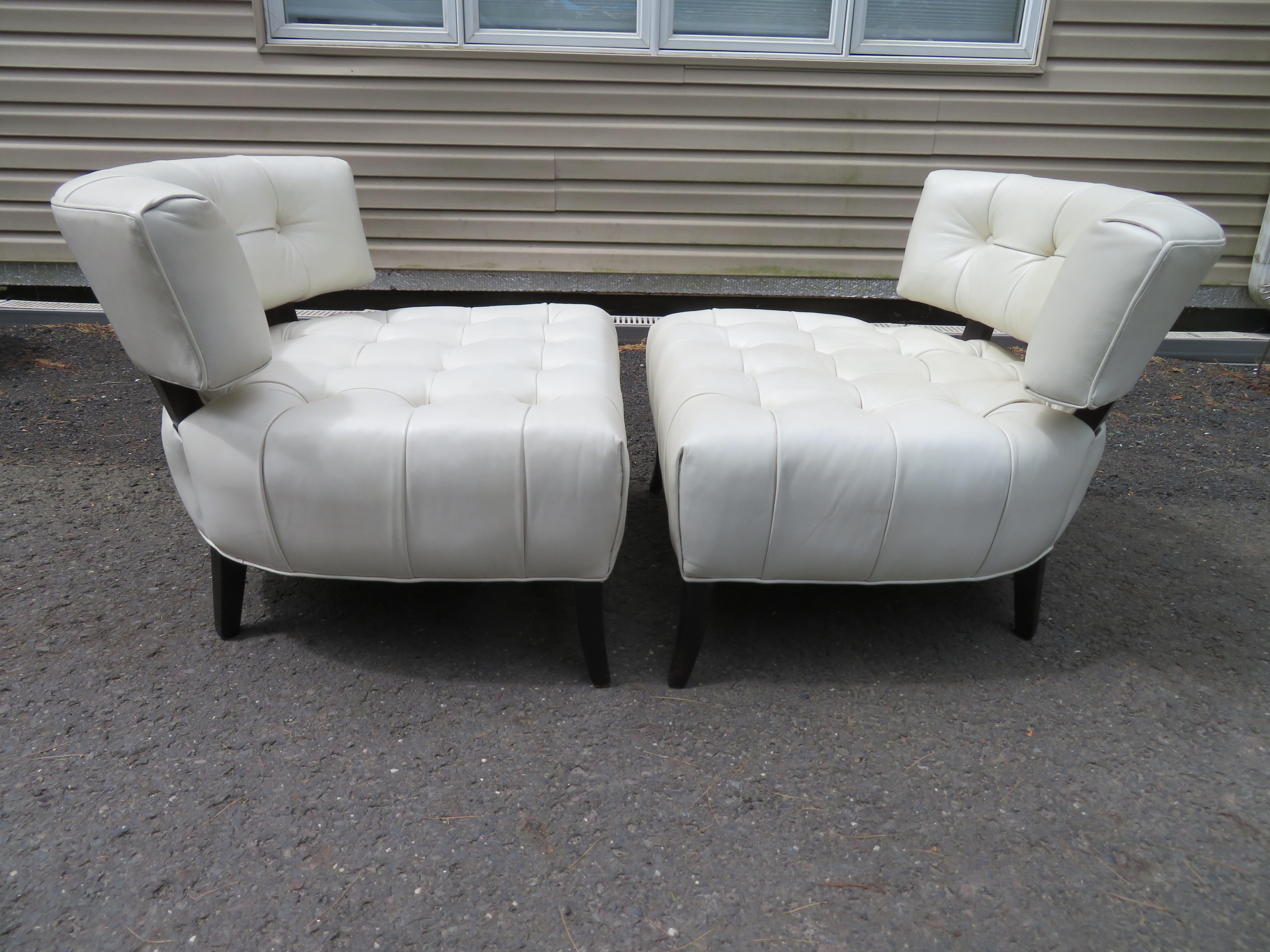 Magnificent pair of Billy Haines style Biscuit tufted slipper chairs. These chairs are upholstered in a lovely high grade creamy white leather and look amazing. They measure 28