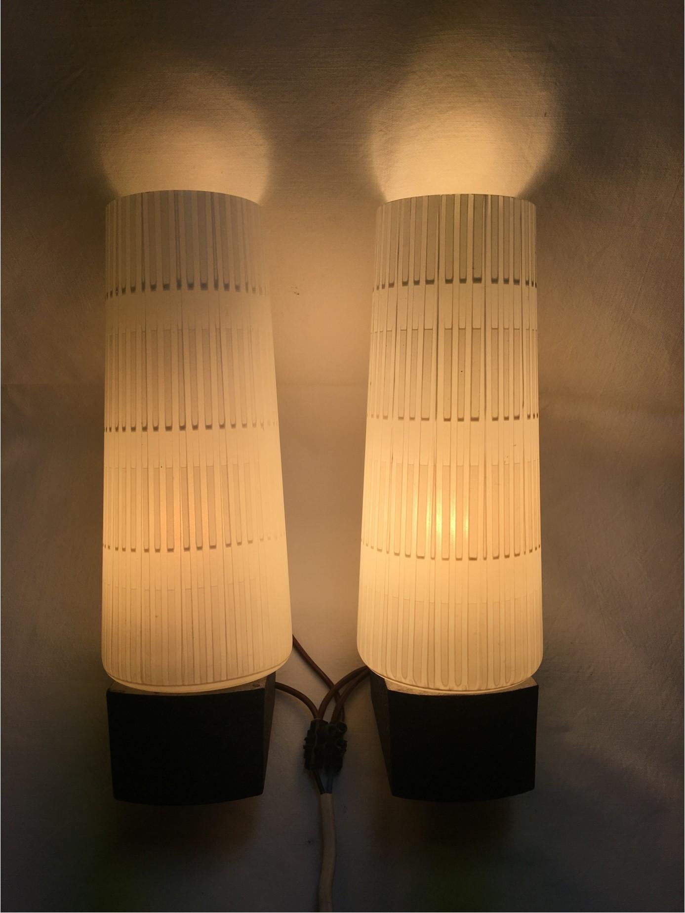 A set of 1960's striped glass Vanity Sconces.  Each lamp has a on/off switch located at the base of the lamp. Very nice white striped glass create a lovely lighting effect. The lamps are rewired to meet U.S. standards. Each requires one E 14