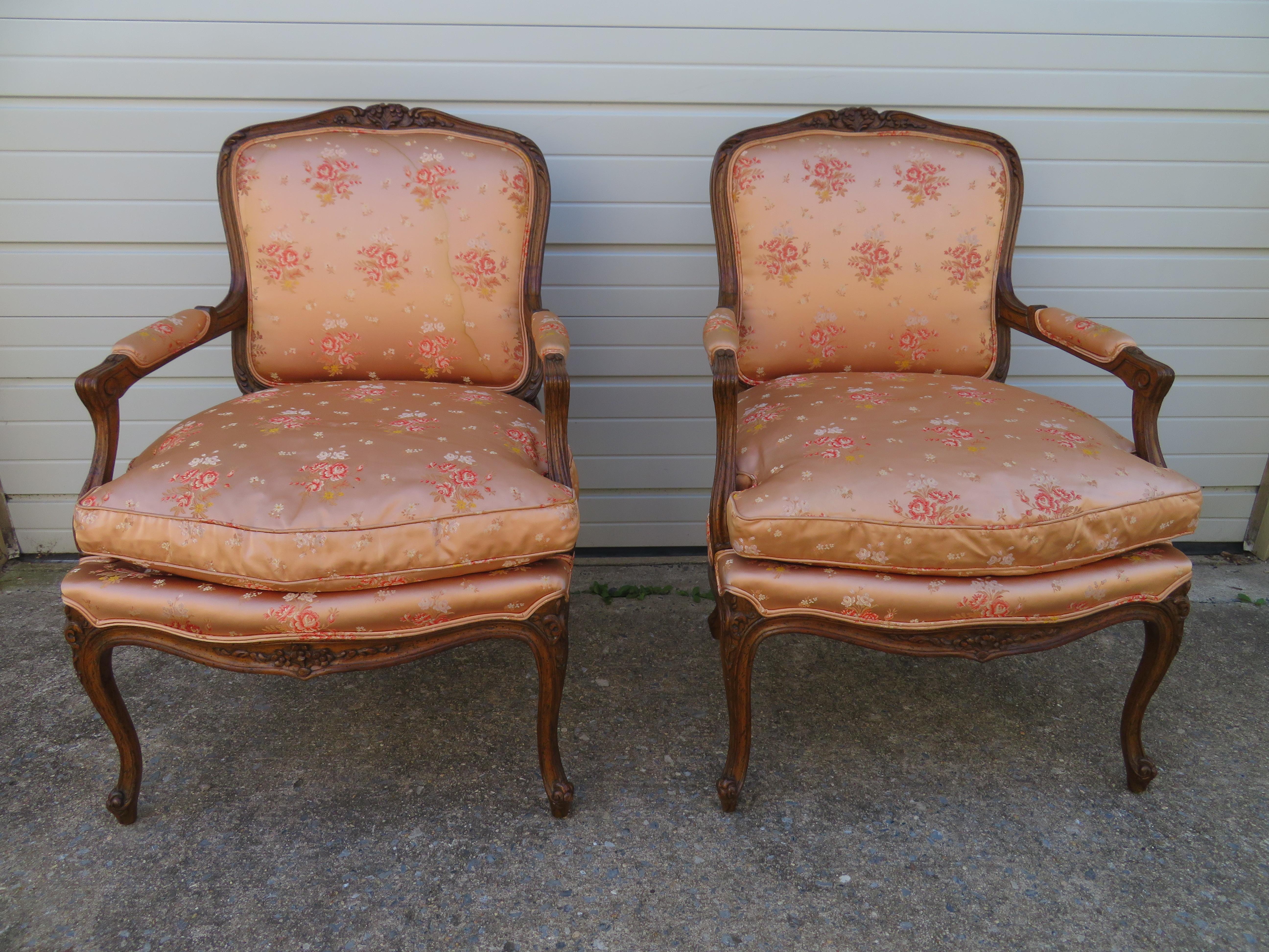 Schönes Paar französischer Louis-XV-Bergère-Stühle aus der Jahrhundertmitte. Die Polsterung scheint original zu sein und zeigt leichte Abnutzungserscheinungen mit einem Wasserfleck auf einer Rückseite. Die Sitzkissen sind mit Daunen gefüllt und sehr