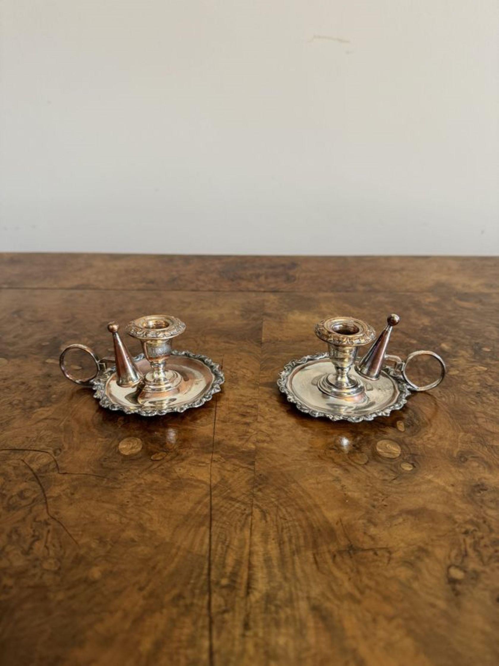 Lovely pair of antique George III silver plated chamber sticks having a quality pair of George III silver plated chamber sticks with an ornate shaped edge, the original snuffers and a circular shaped handle to the back.

D. 1800 