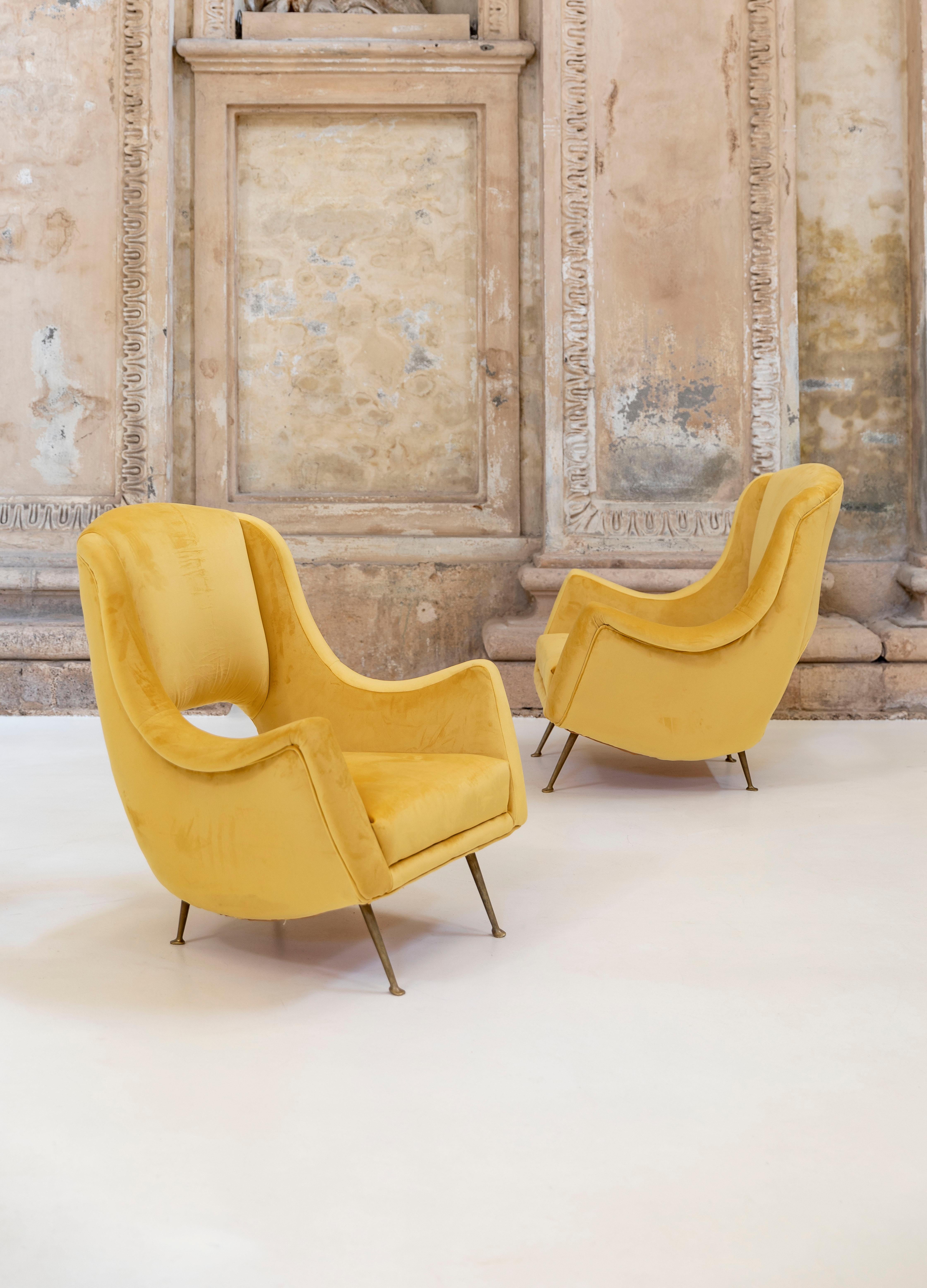 Lovely pair of armchairs attributed to Carlo de Carli.

Solid brass legs and elegant yellow velvet upholstery.

Newly reupholstered.

Shaped and open back seat.