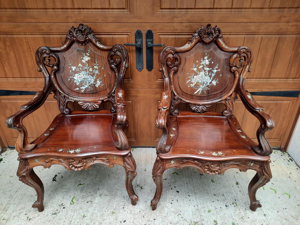 Gorgeous pair of Asian carved rosewood armchairs from Singapore having detailed mother of pearl inlay of flowers, leaves, birds and butterflies. Backs of chair are also finished and beautiful. Cushions need recovering and there are signs of age to