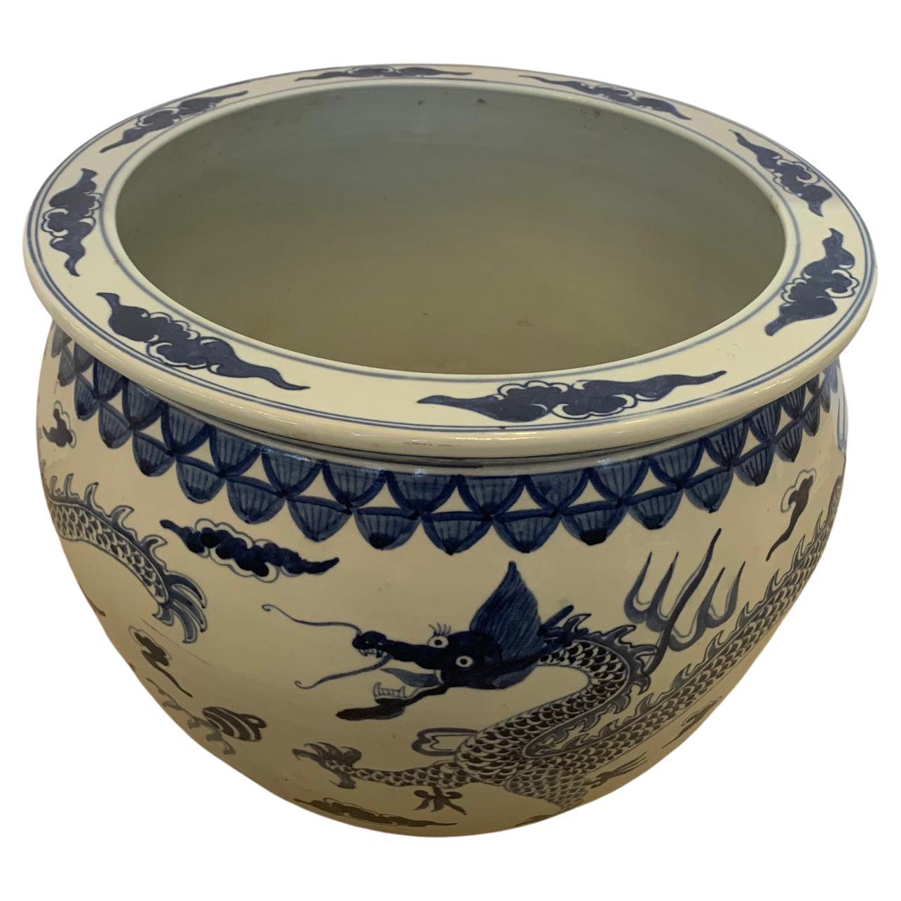 Classic pair of Chinese blue and white planters, each with its own unique decoration, which adds interest to the pairing.
One has figural design with pagodas; the other dragons.