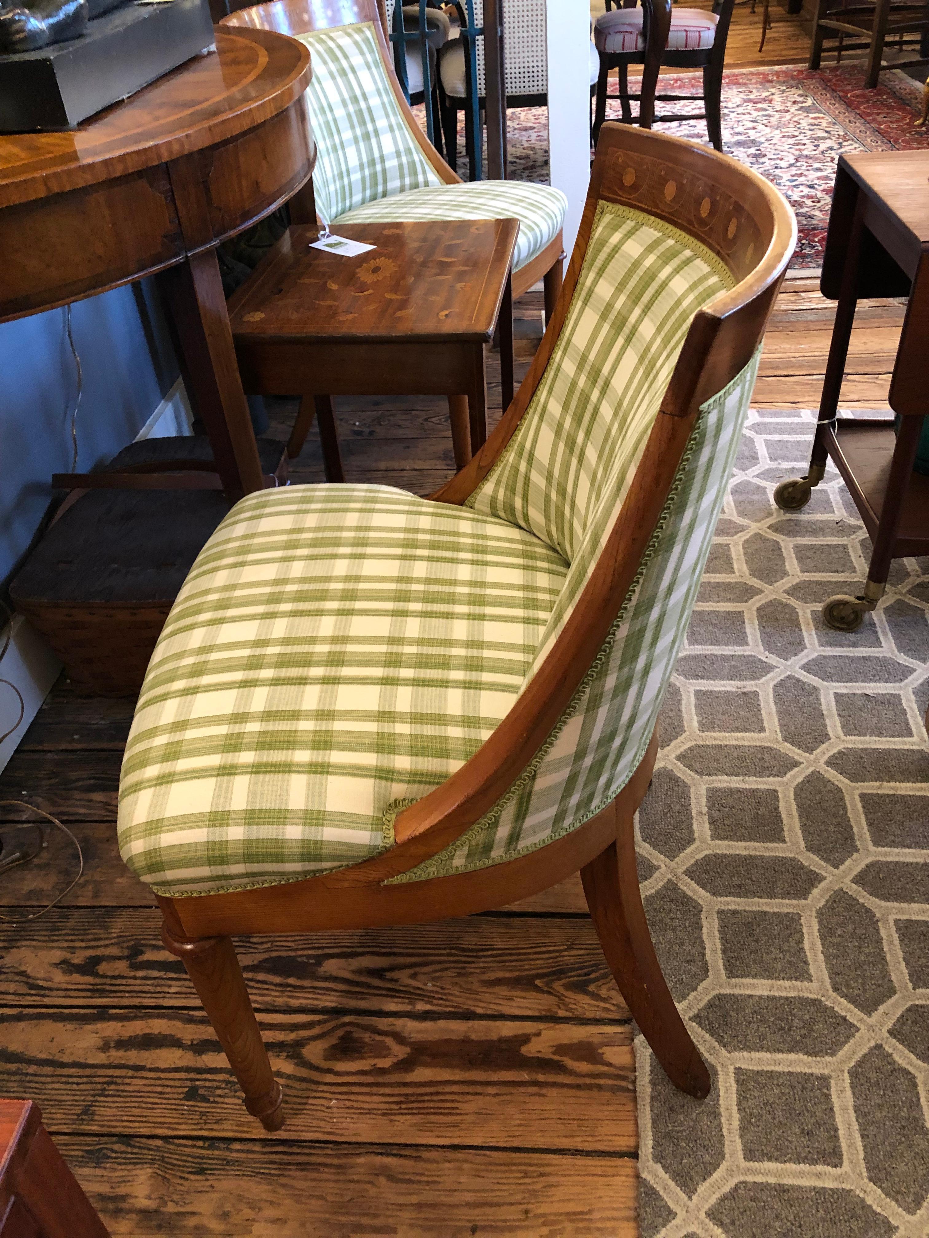 A lovely pair of small curvy salon chairs having beautiful inlaid wood frames, probably a mix of woods including fruitwood. Upholstery is an updated green and cream plaid.