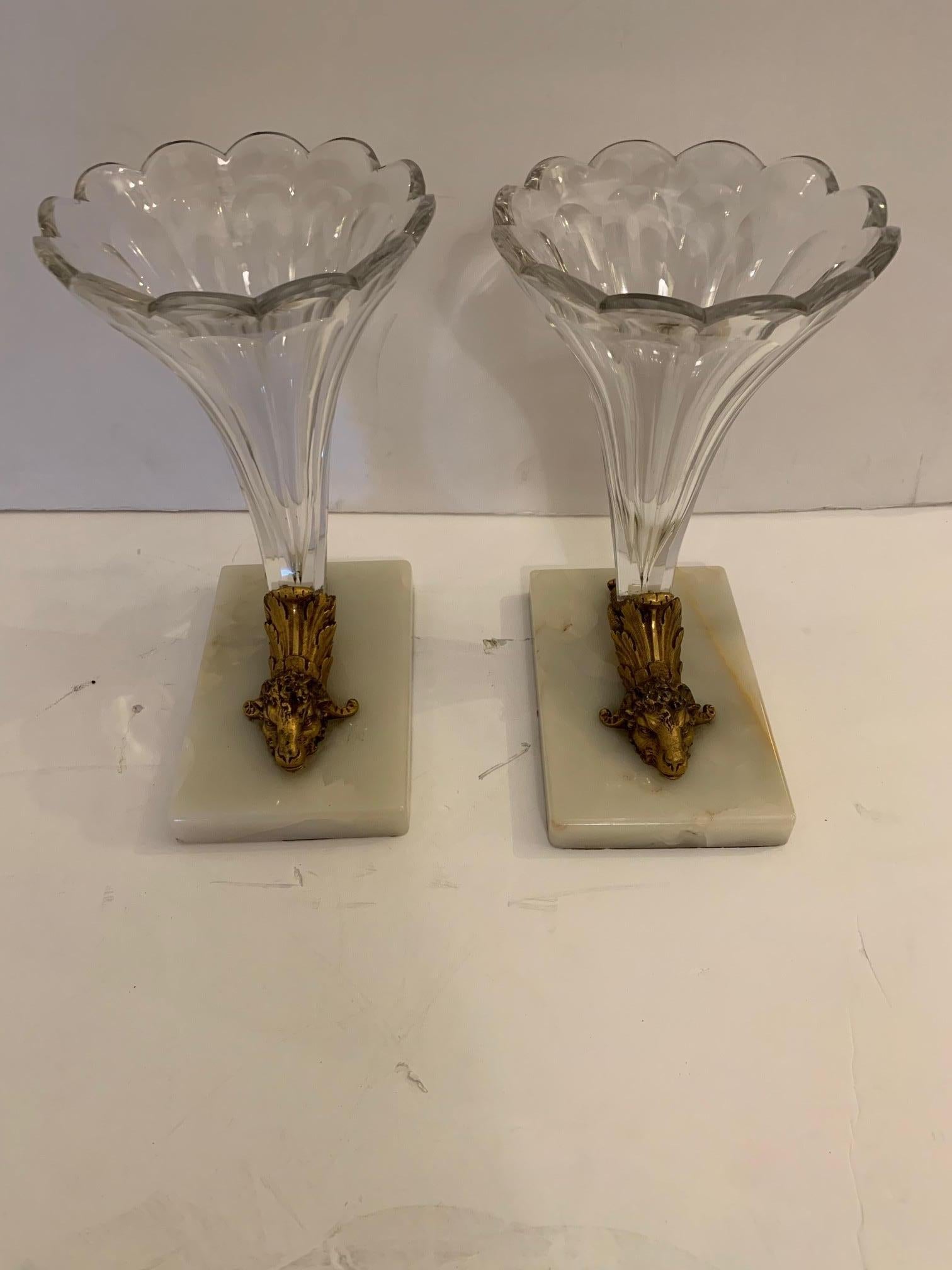 A beautiful pair of cut glass cornucopia or garniture having white marble bases and stunning bronze decorative rams heads.