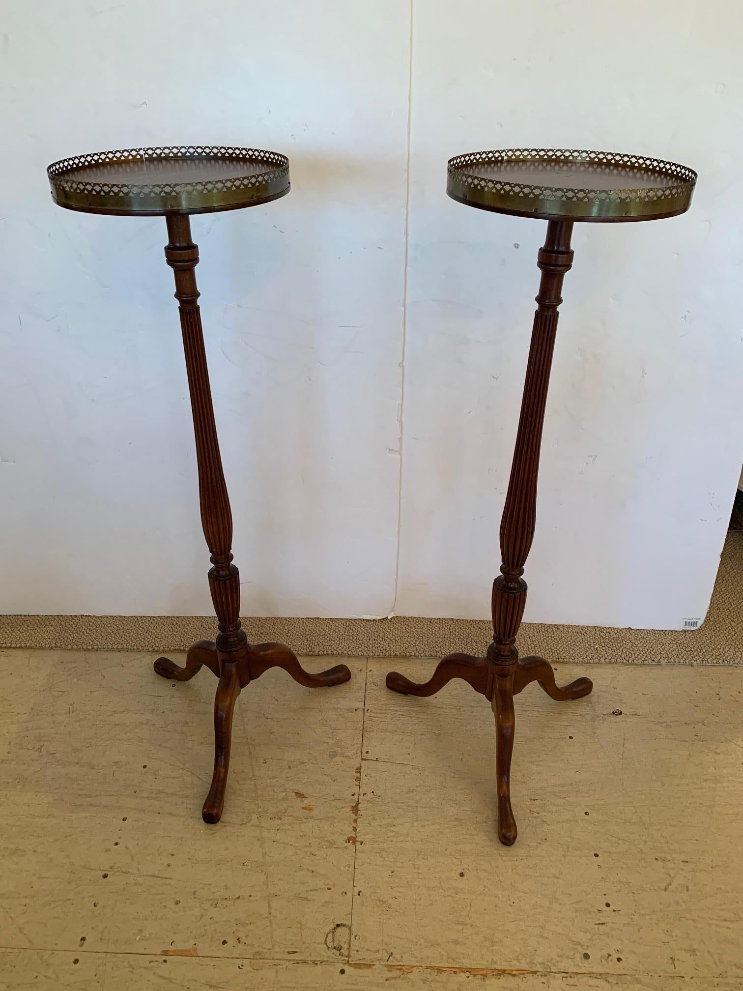 Lovely pair of round mahogany plant stands having pierced brass gallery, reeded columns and tripod cabriole legs.