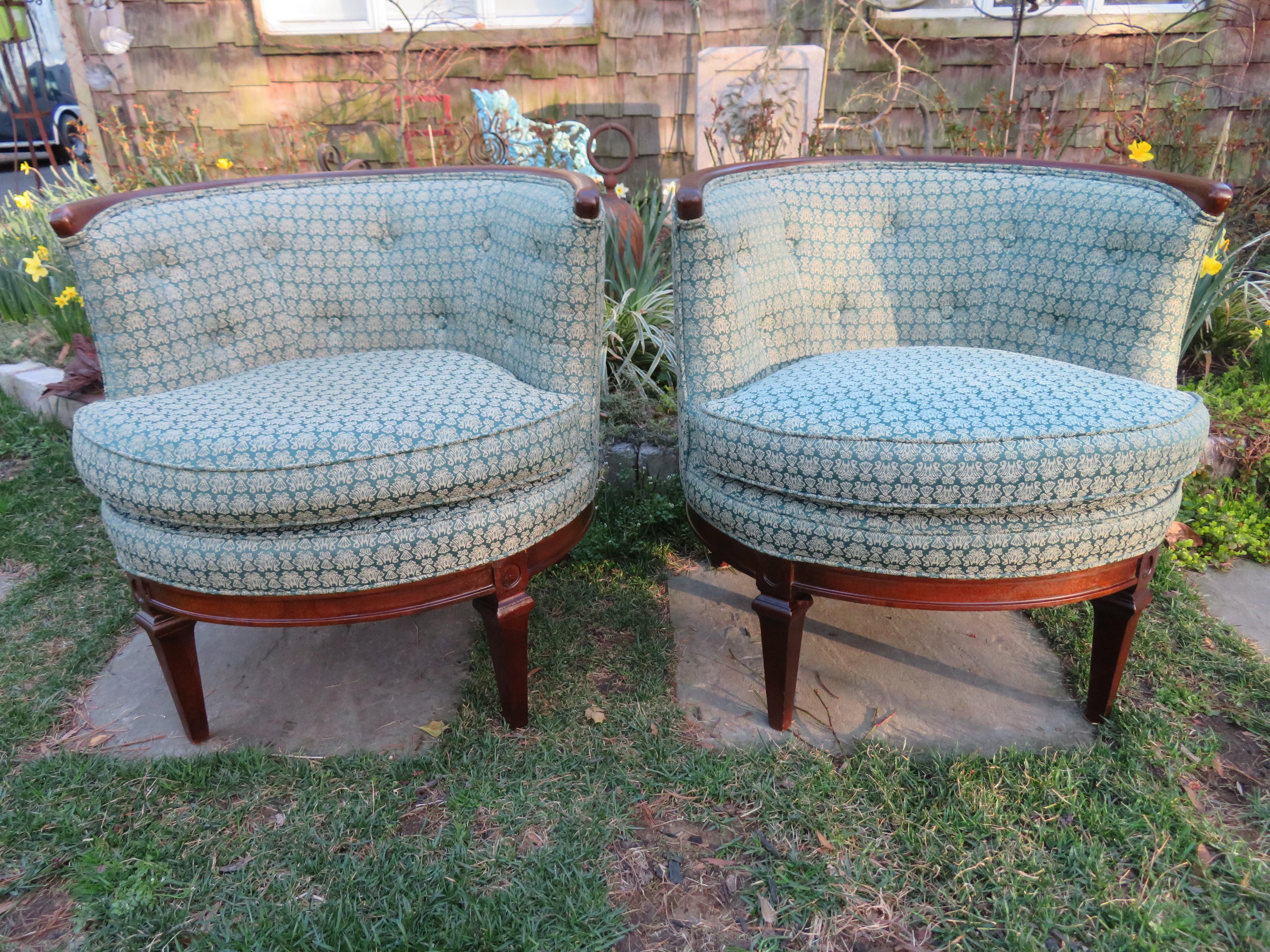 Lovely pair of Hollywood regency barrel back lounge chairs. Wonderful distressed wood details the edge of the barreled backs. We love the scale and style of this vintage pair.