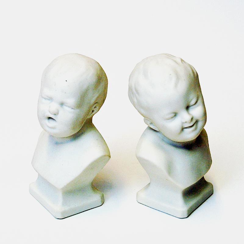Pair of cute children figurines made of white parian porcelain by Gustavsberg, Sweden 1920 and 1921. One figurine shows a happy smiling child and the other a sad crying child. Makes a great figurine couple displayed on a fireplace mantel, window,