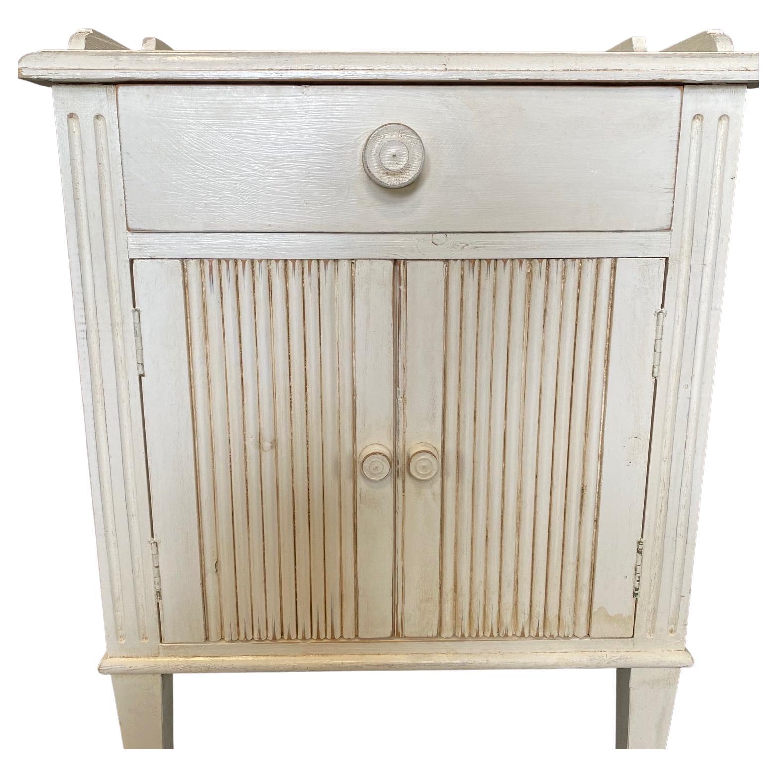 Really classic and lovely pair of cream painted Swedish Gustavian style night stands, bedside tables or side tables having single drawer and double doors with storage within.

Measures: Surface top is 27