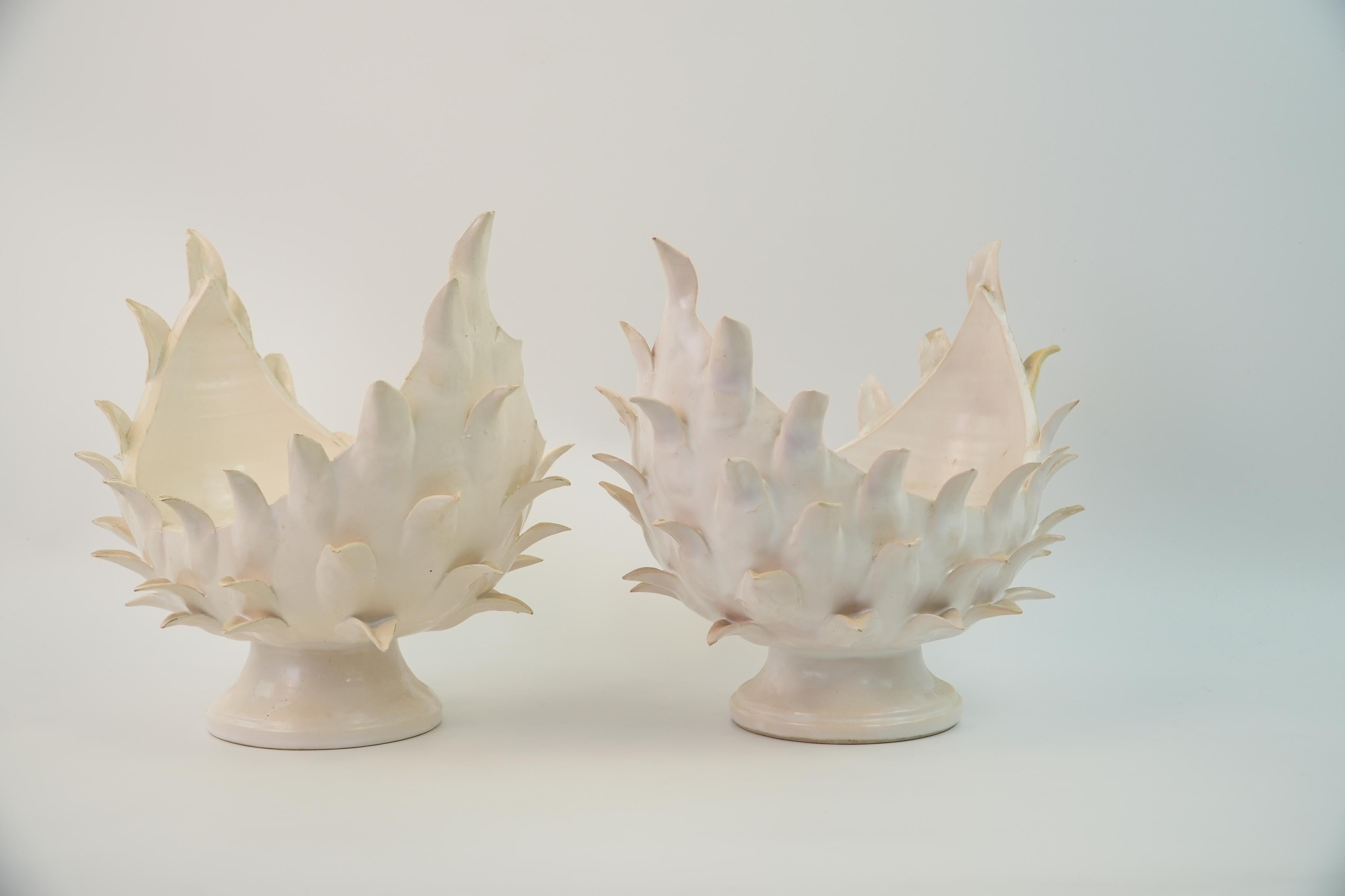 Si tratta di una coppia di cestini o portafrutta in ceramica della metà del secolo scorso disegnati da Jean Roger Paris negli anni '60. Ogni pezzo presenta una forma organica e scultorea con estensioni simili a petali disposti in un motivo a fiamma.