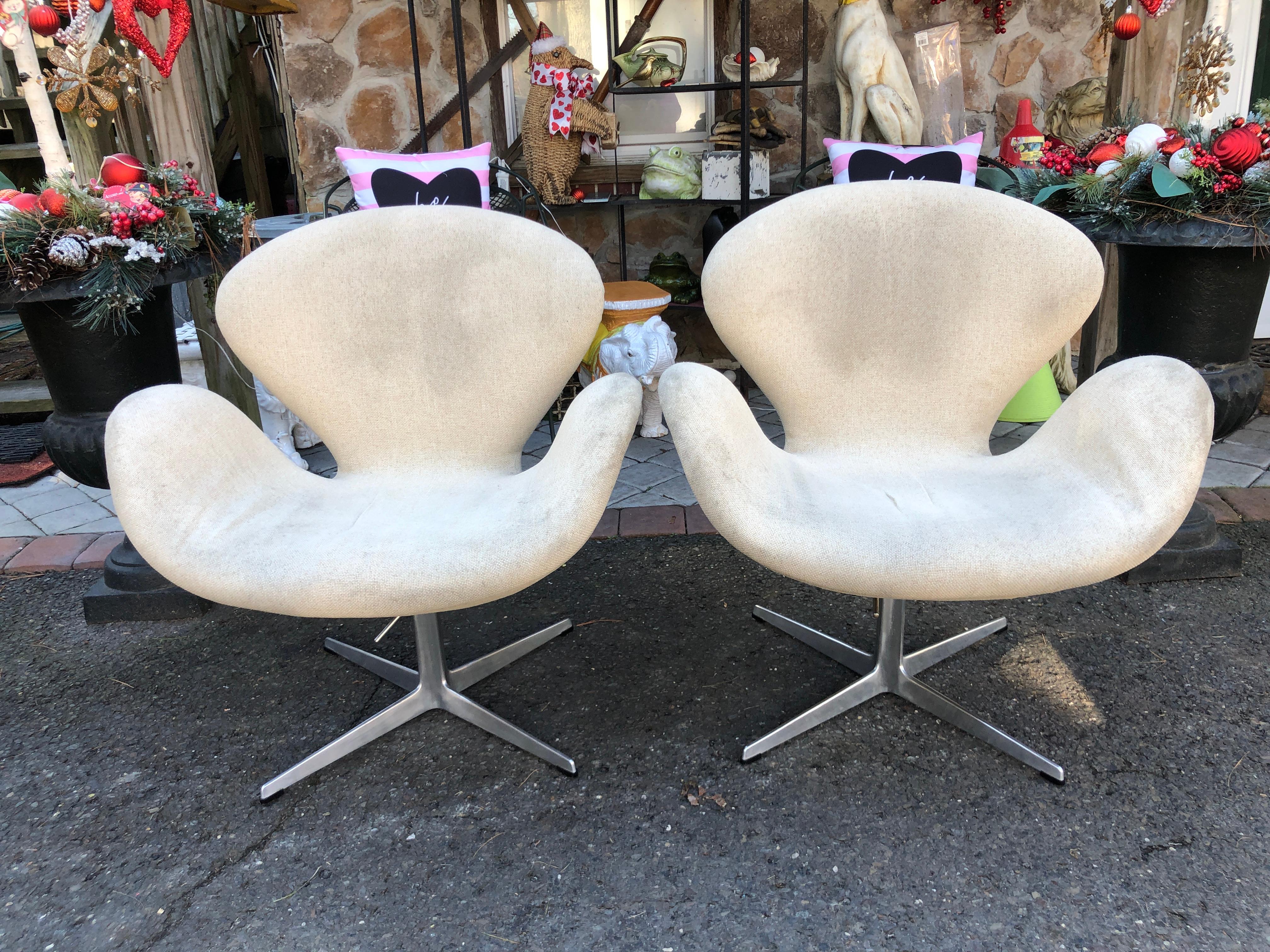 Lovely pair 1960s Swan chairs designed by Arne Jacobsen for Fritz Hansen. With brushed aluminum swiveling four-star base-all glides are present. This version of the swan chair features a rare height adjustment functionality which can be set by the