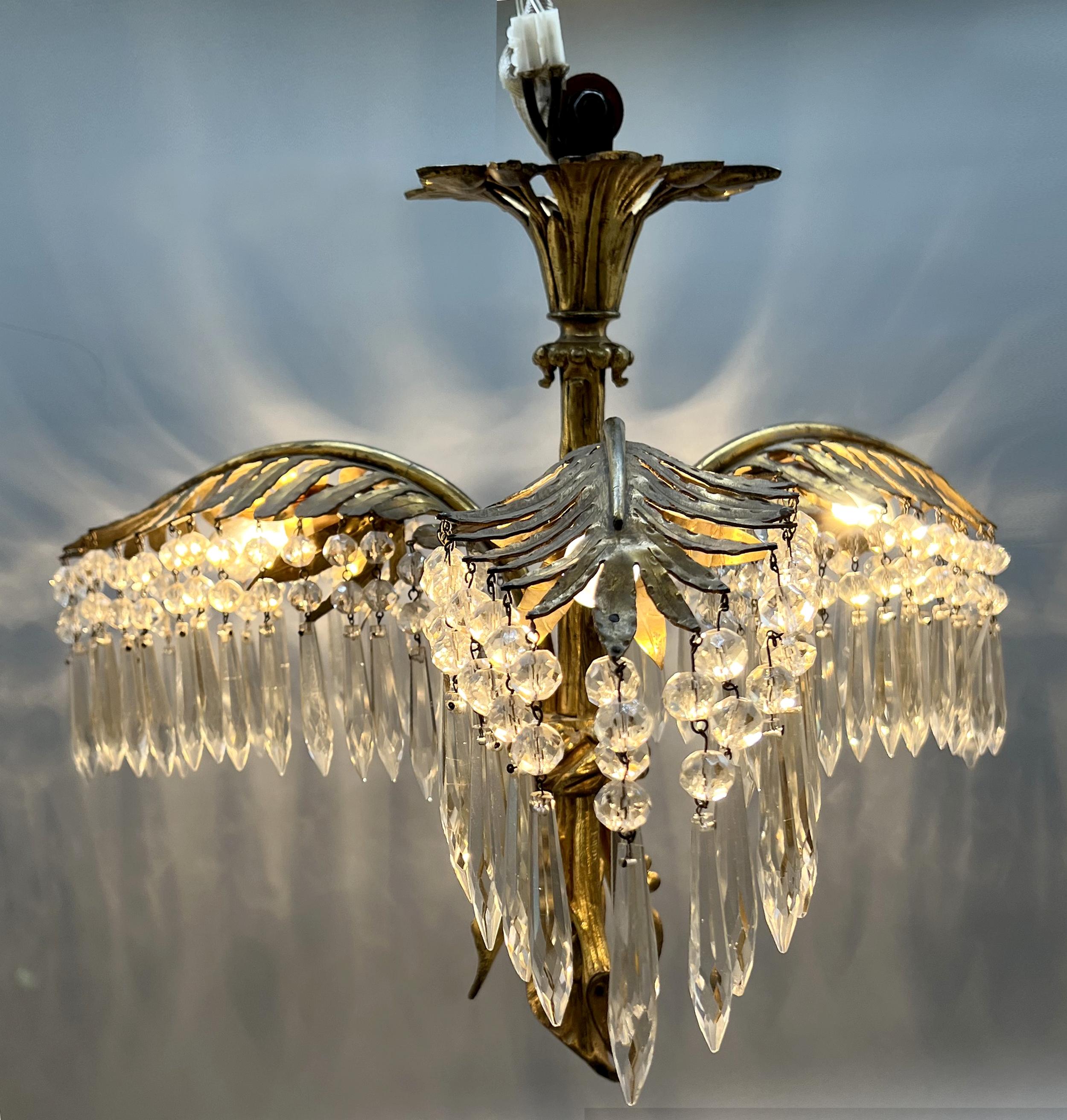 Attractive small ormolu chandelier from the 1900's featuring three palm branches linked together by a cord. 
The palms support numerous faceted crystal pearls and pendants.
Three lights.