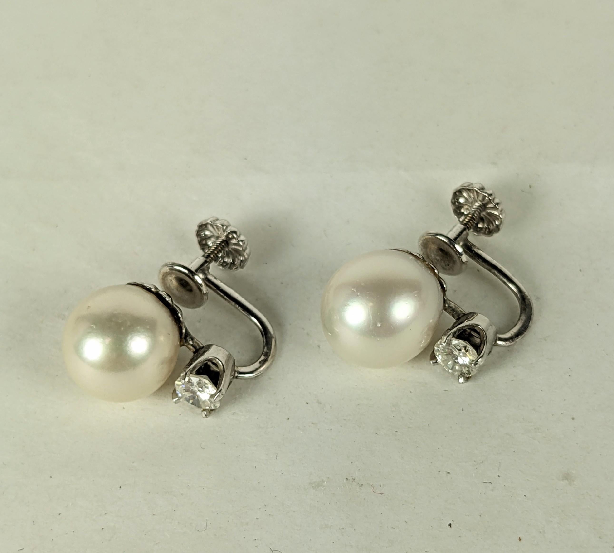 Classic Cultured Pearl and Diamond Earrings from the 1950's. Set in 14k White gold with screwback fittings and large 10mm creamy white cultured pearls and .25 carat diamonds under each pearl. .50 carat total diamonds. 1950's USA. 