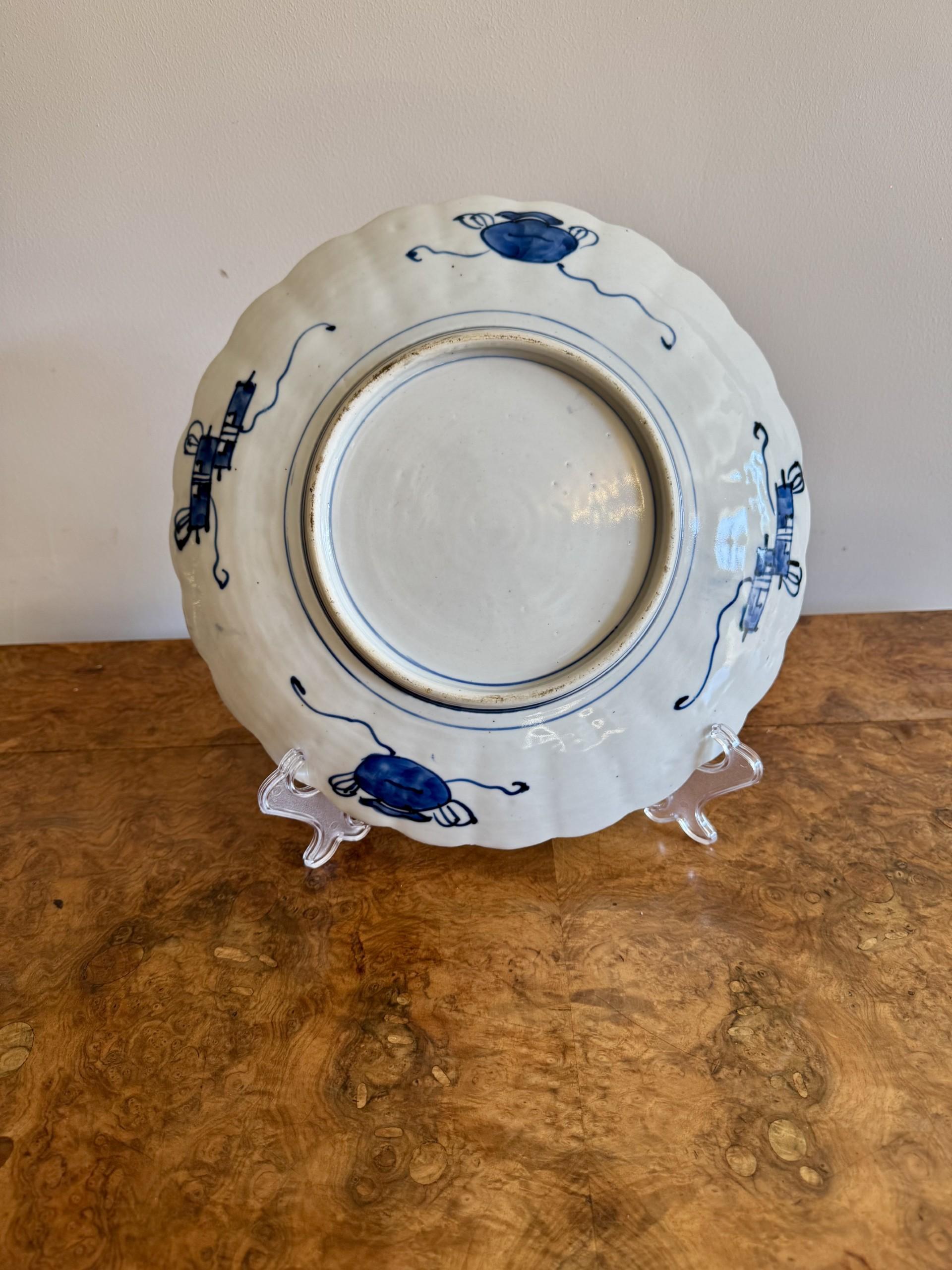 Precioso plato imari japonés antiguo de calidad, con borde ondulado, decorado con una bonita cesta de flores en el centro rodeada de paneles con pájaros, hojas y flores, pintado a mano en colores rojo, blanco y azul.

D. 1900