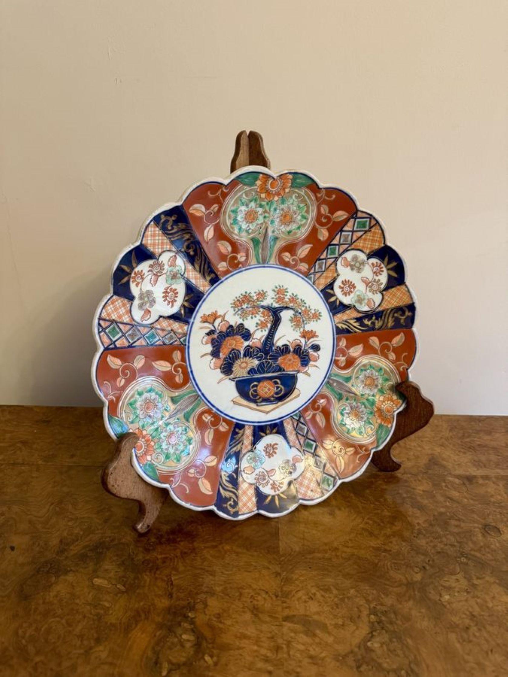 Lovely quality antique Japanese imari plate, having a quality antique Japanese imari plate with a scallop shaped edge, decorated with a basket of flowers to the centre surrounded by panels with flowers and scrolls hand painted in stunning red,