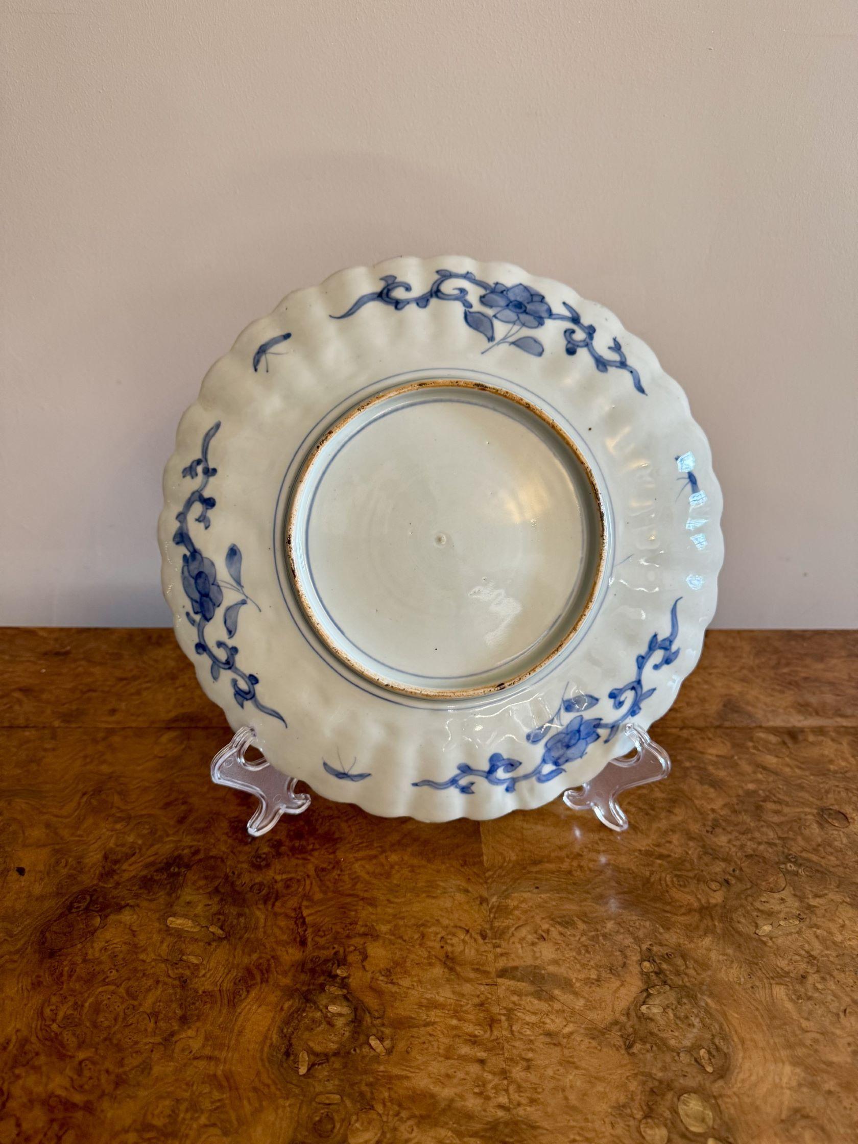 Precioso plato imari japonés antiguo de calidad, con borde ondulado, muy decorado con flores y hojas pintadas a mano en impresionantes colores rojo, blanco y azul.

D. 1900