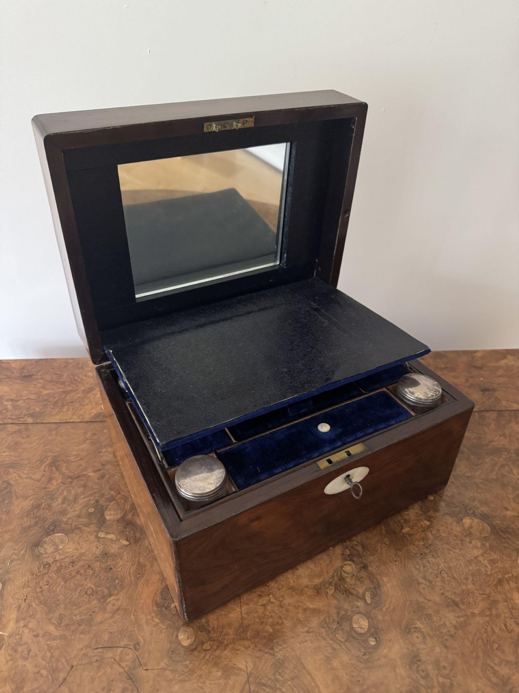 Graziosa scatola di vanità di qualità in legno di palissandro vittoriano, con un coperchio incernierato con cartiglio in madreperla, che si apre per rivelare uno scomparto foderato di porpora con un fronte di caduta e uno specchio sul coperchio