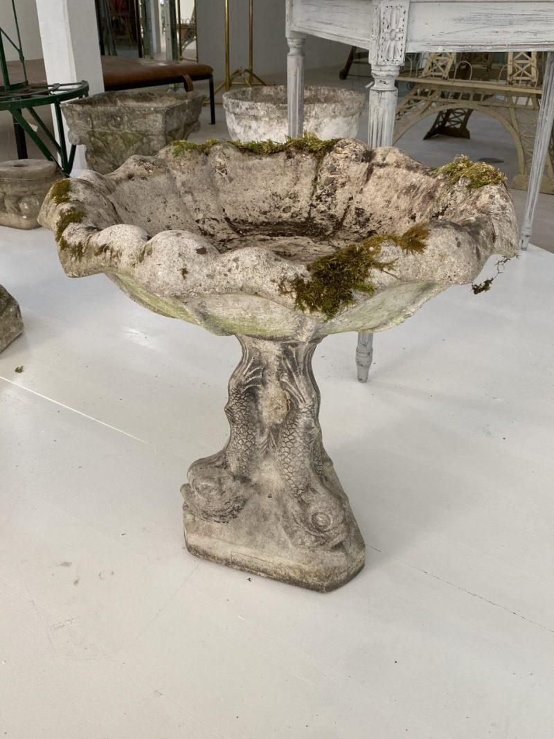 Beautiful and harmonious midcentury French jardiniere/garden pot, cast in cement and shaped as a sumptuous clamshell, resting on a plinth decorated with fish motifs.

Lots of wonderful weathered patina and a certain eye-catcher in your garden,