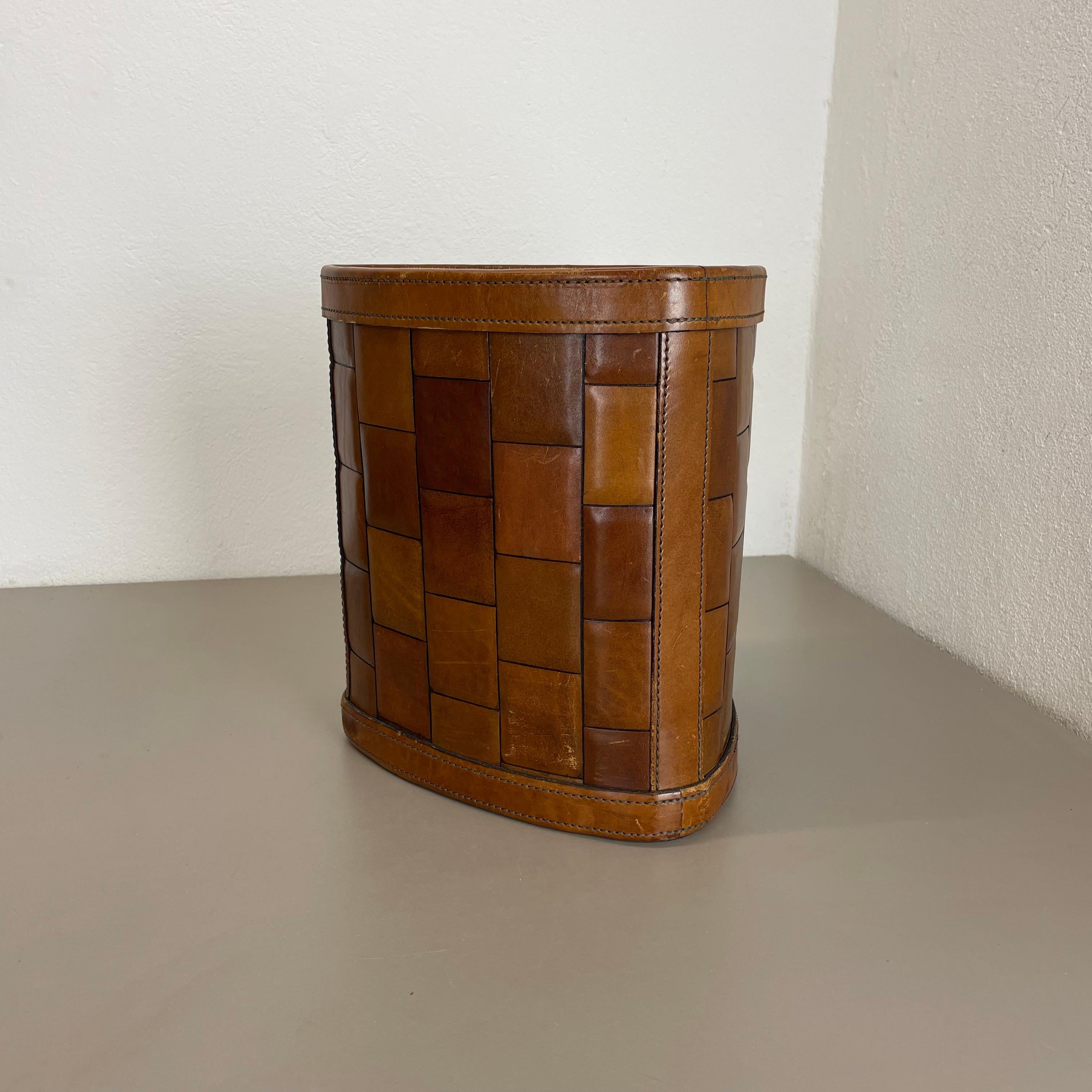 Article: waste bin paper bin basket

Origin: Germany

Age: 1960s

This original vintage Auböck style waste bin paper bin basket was produced in the 1960s in Germany. It is made of natural leather in a nice patchwork optic. this item has a fantastic