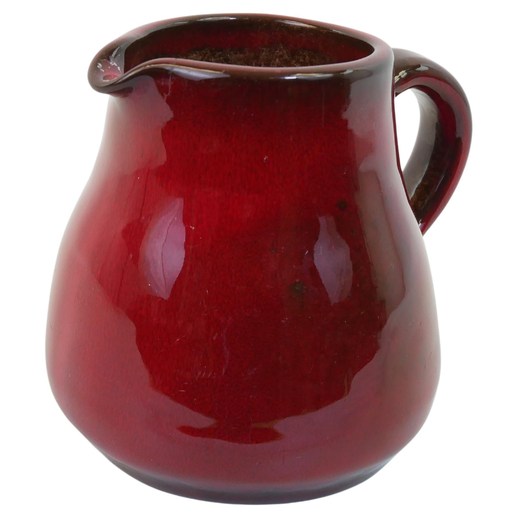 Lovely red ceramic pitcher firmed in the style of George Jouve