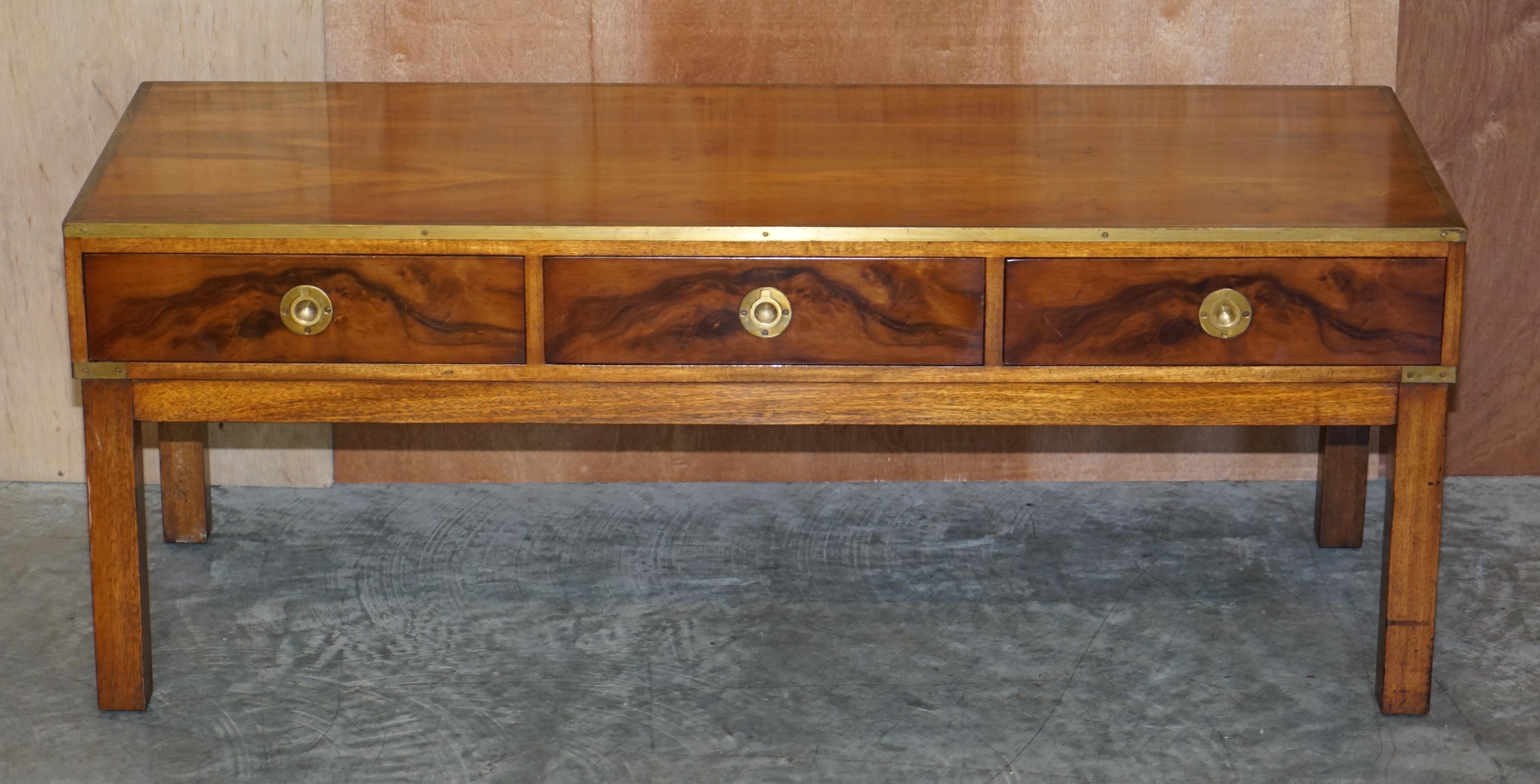 We are delighted to offer this vintage collectable burr walnut & brass Harrods London Military Campaign three drawer coffee table made by Kennedy

This piece was sold through Harrods, it was made by Kennedy who were Harrods oldest concession, they