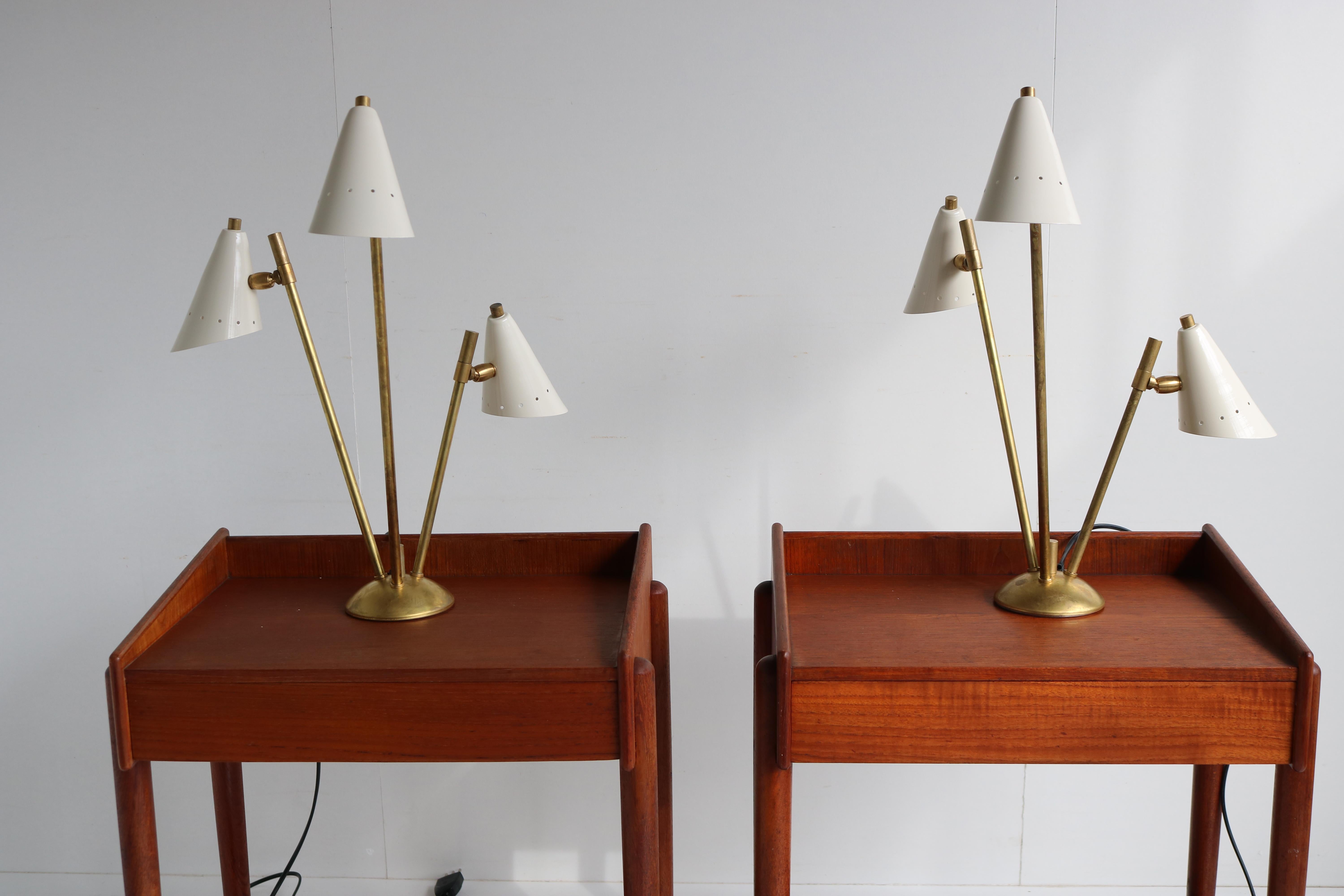 Gorgeous pair of Italian 1950 design table lamps/lights in the style of stilnovo. 
Patinated brass frame with white metal shades. The shades can be adjusted to a desired angle.
They combine really well with teak as seen in pictures. 

Rewired
