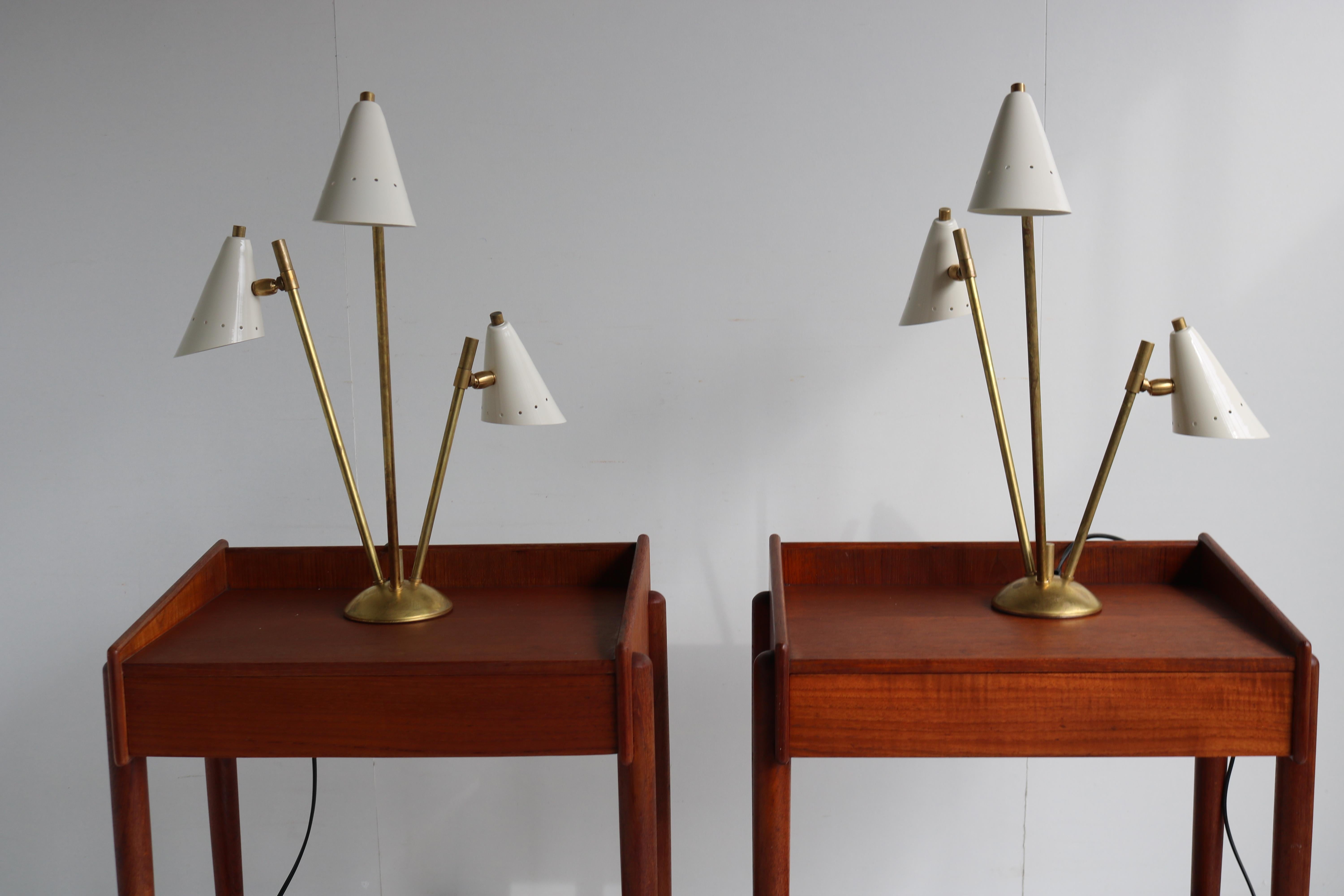 Gorgeous pair of Italian 1950 design table lamps/lights in the style of stilnovo. 
Patinated brass frame with white metal shades. The shades can be adjusted to a desired angle.
They combine really well with teak as seen in pictures. 

Rewired