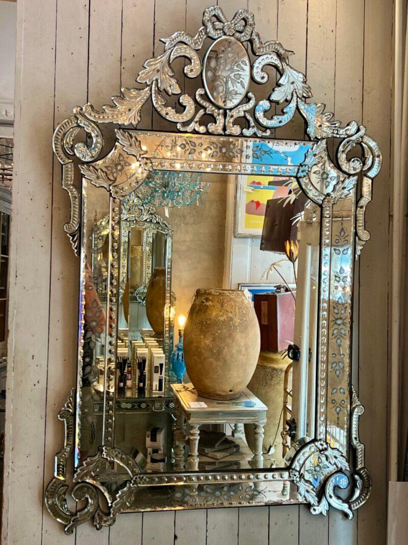 This stunning Venetian mirror from 1920 is a magnificent example of the craftsmanship of the time.

The frame is made of richly ornamented mirrored glass, with hand-engraved motifs, depicting floral and foliage patterns.

The top is adorned with an