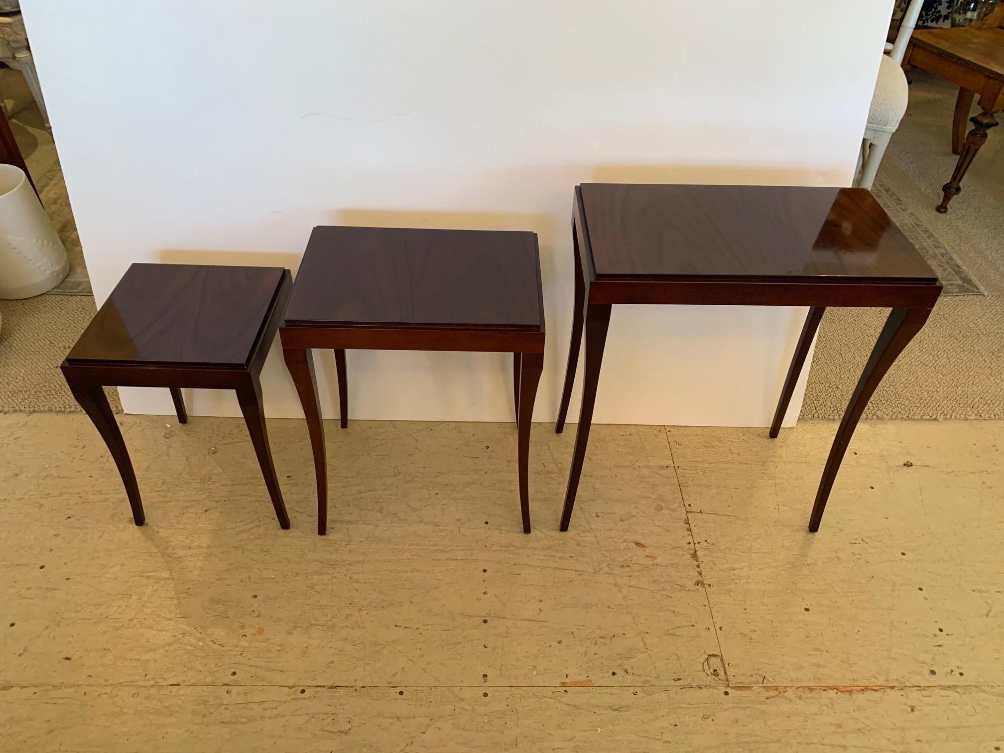 Versatile sleek high gloss mahogany set of 3 nesting tables with lovely thin tapered legs.
Large: 24” H x 12” D x 20.5” W
Medium 20.25” H x 11.75” D x 16” W 
Small: 16.5” H x 11.75” Square.