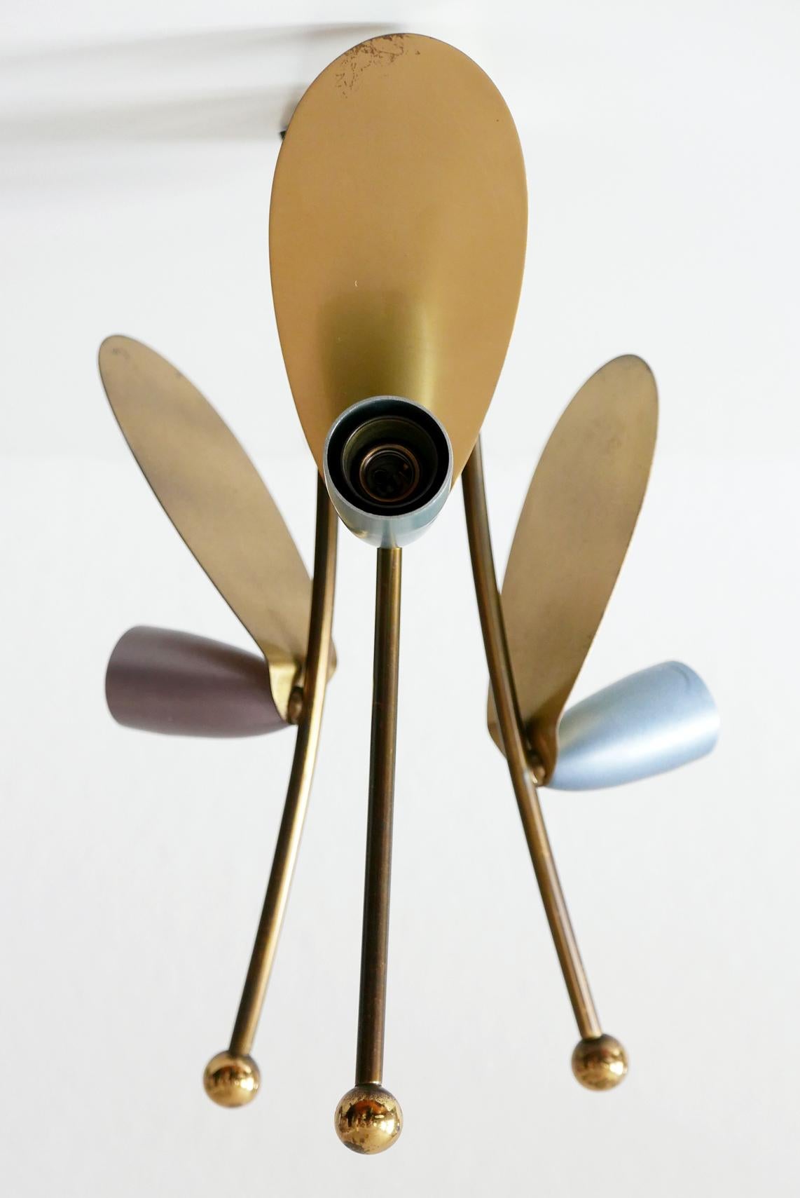 Joli plafonnier Sputnik à trois bras, de style moderne du milieu du siècle. Fabriqué dans les années 1950 en Allemagne.

Réalisée en laiton et en aluminium laqué rouge, vert, bleu et violet, la lampe nécessite 3 ampoules à vis Edison E14, est câblée