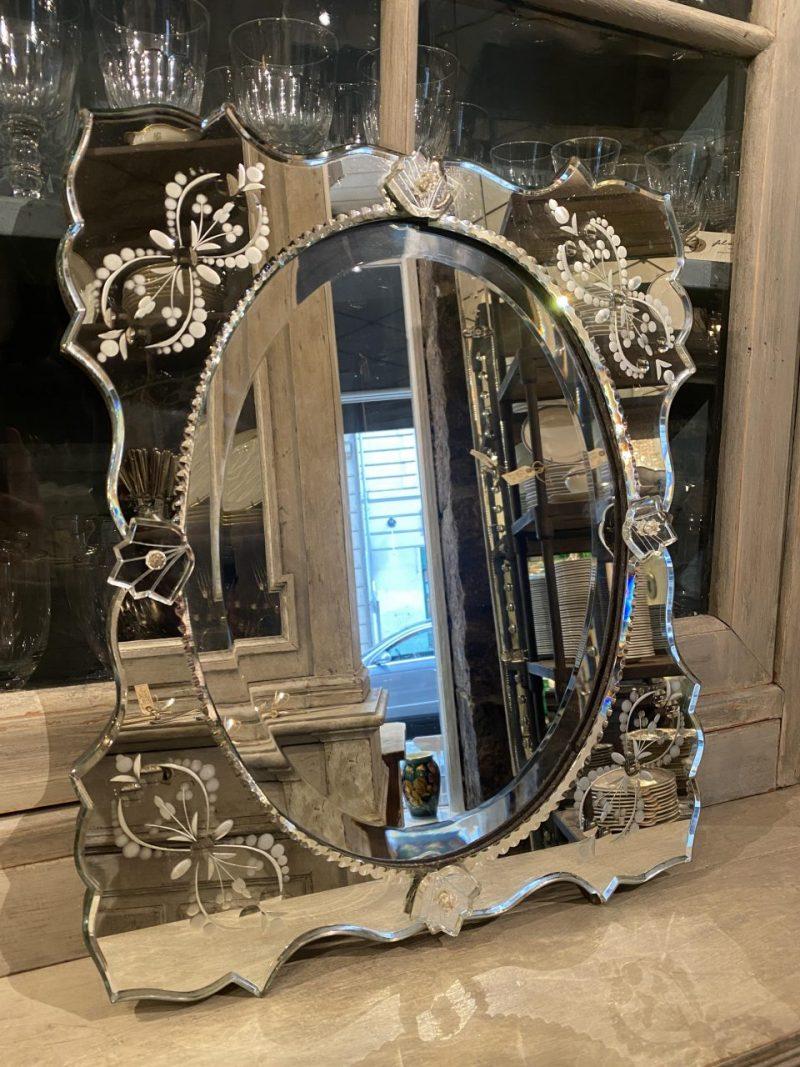 Gorgeous Venetian mirror from France circa 1920-1930s, with beautifully faceted mirrored glass.

Wonderful floral ornamentation along the mirrored frame.

A delightful and elegant piece that would look lovely in any hallway or perhaps in a