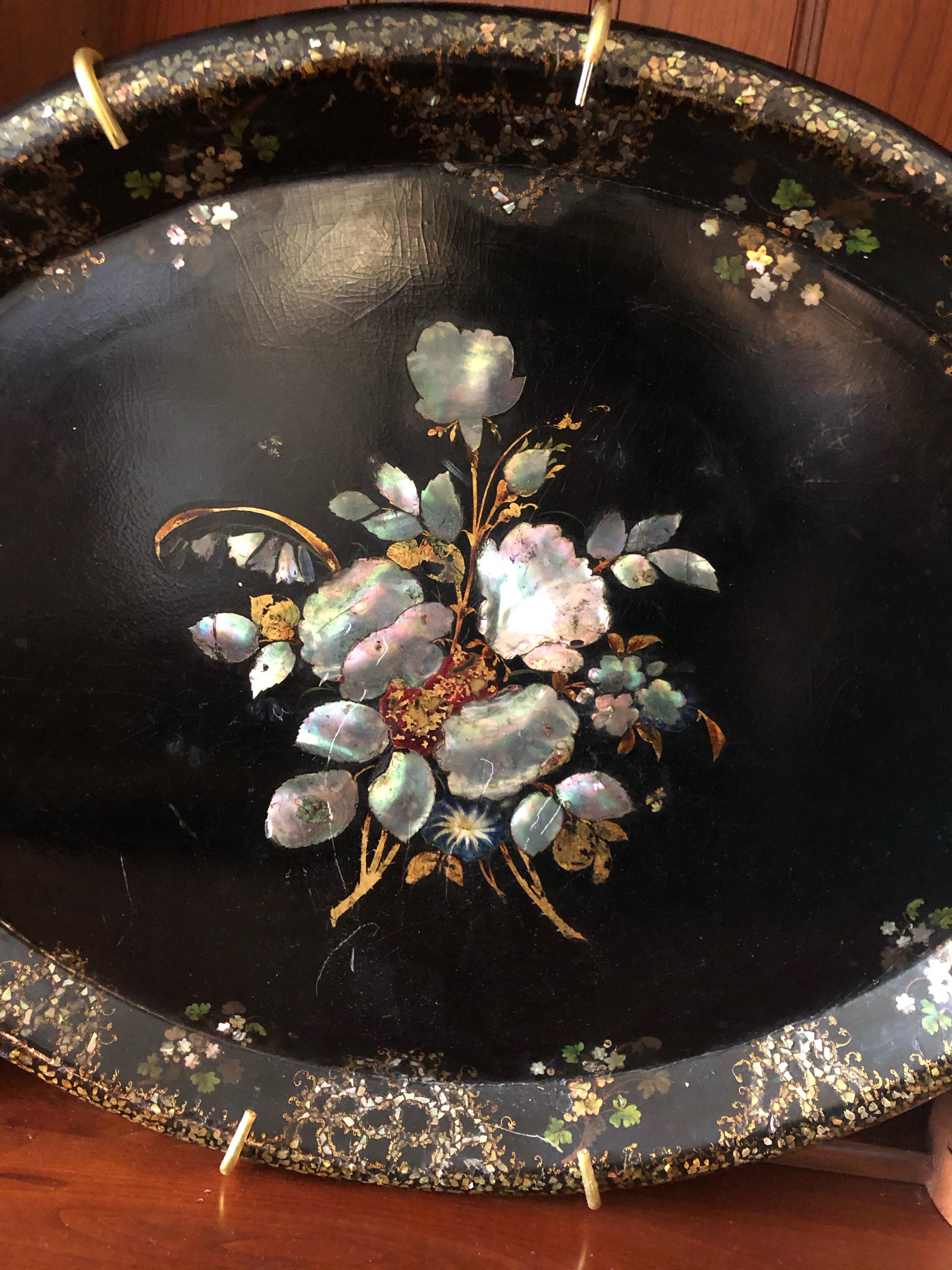 Antique papier-mâché oval black platter with mother of pearl inlay that makes a beautiful piece of art for the wall. Hanging hardware attached. 
   