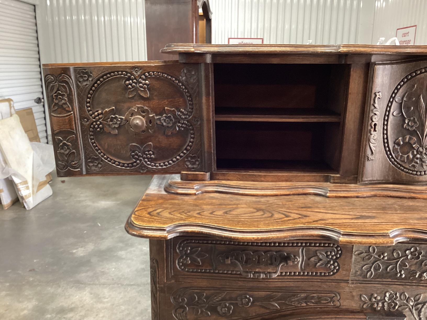 From the Provence region of France, this beautifully carved buffet has a 2-door lower cupboard with an upper cupboard having sliding doors that reveal more storage space. What is most noteworthy on this piece are the multiple carvings on the doors.
