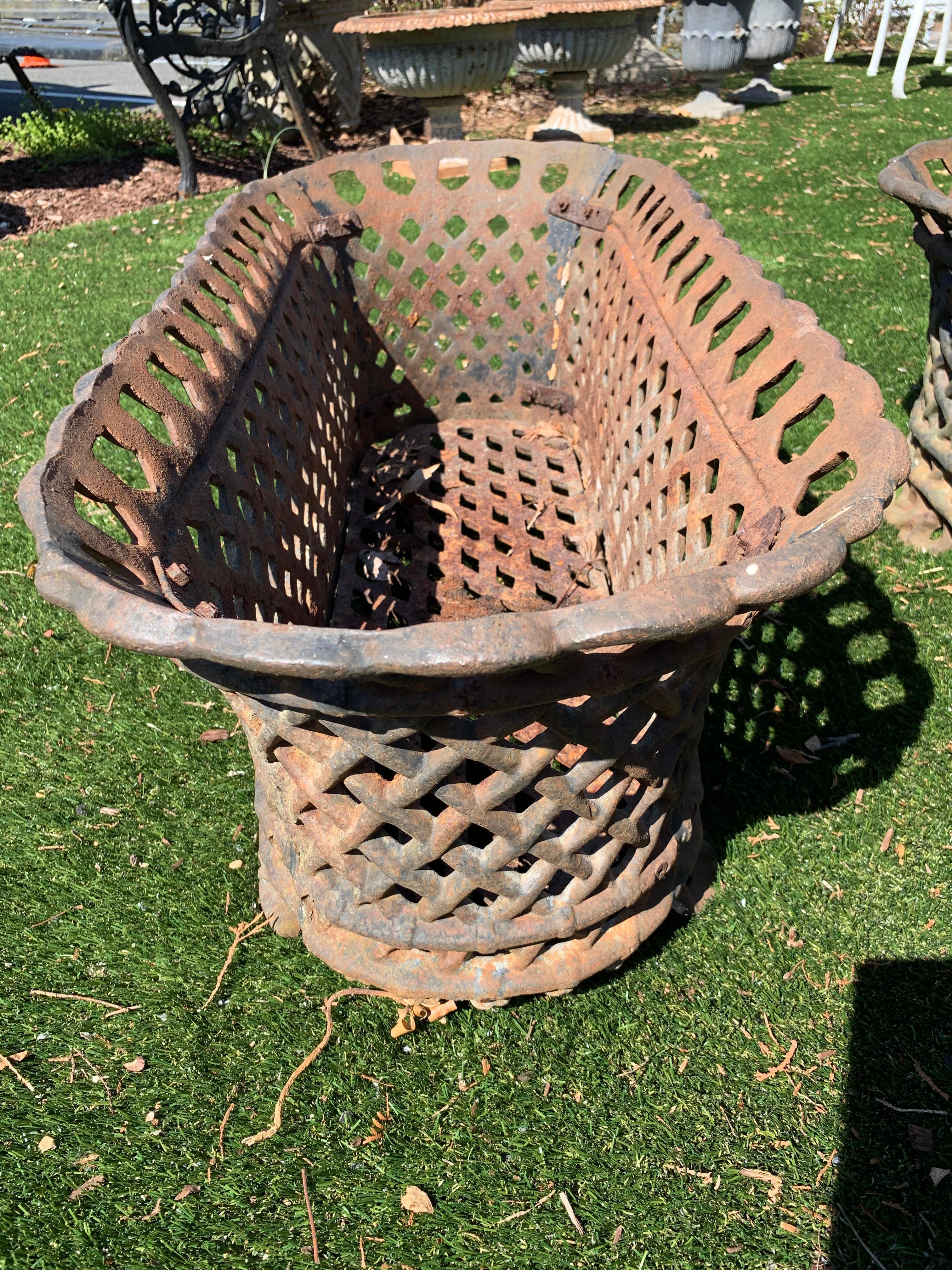 Beautiful pair of vintage iron oblong shaped basket motife planters having woven bands of iron and lovely chain link decoration around the top. Naturally aged rust patina.