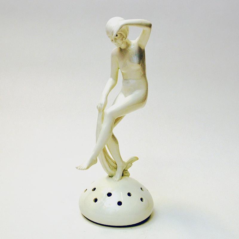 Elegant woman sculpture figurine flower holder of white porcelain made in Czechoslovakia in the 1940s. Elegante sculpture originally meant for flower arrangements to be placed on top of a plant holder having the plant grow up through the holes on