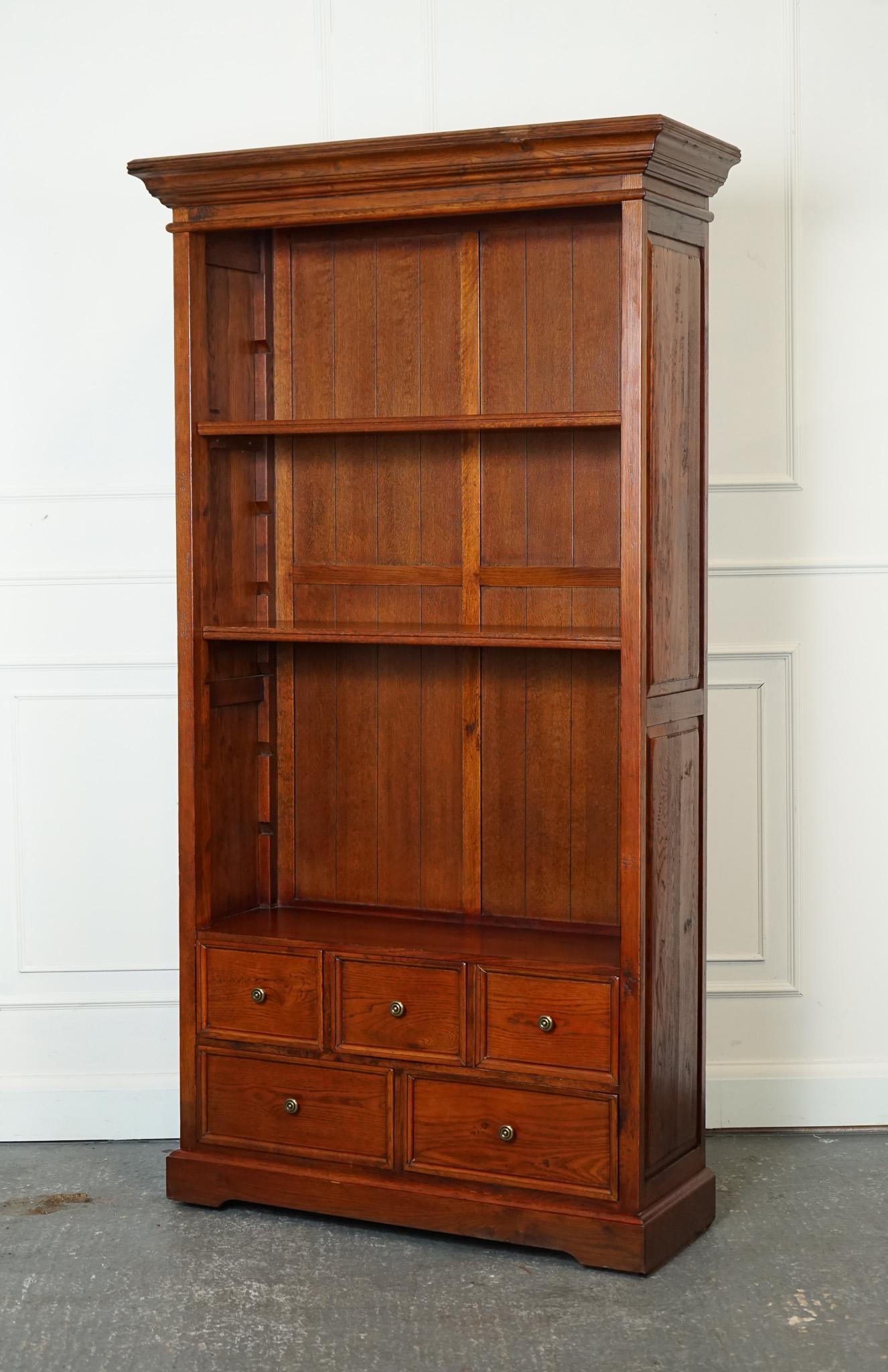 

We are delighted to offer for sale this A Lovely Vintage Teak Open Bookcase With 5 Drawers And Brass Handles .

This piece exudes a warm and inviting charm while showcasing the natural beauty of teak wood. This piece would likely feature a rich